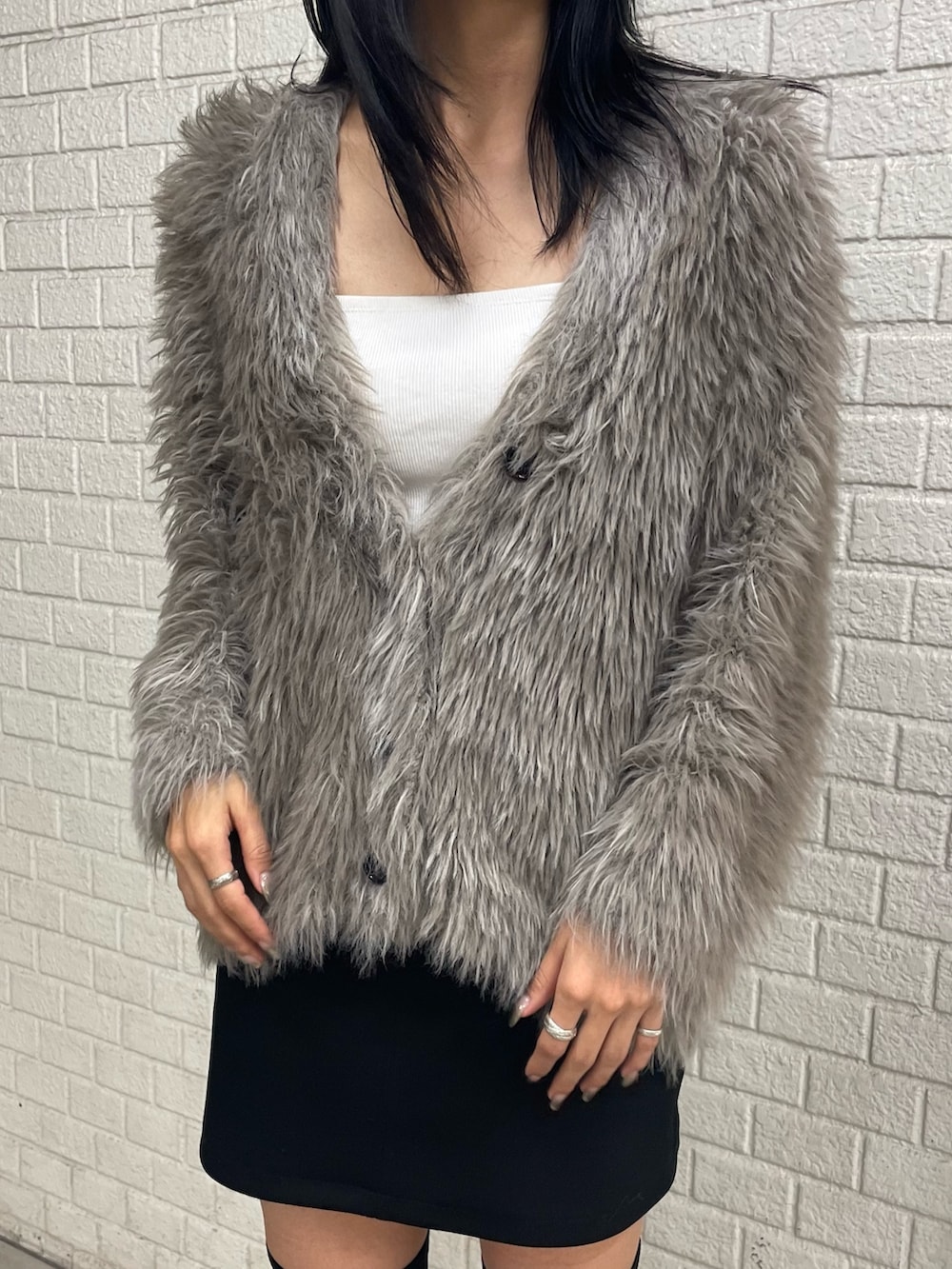 グレー系のカーディガン/ボレロ、ホワイト系のTシャツ/カットソー、ブラック系のスカートを着用したレディースの秋コーディネートの4枚目の写真