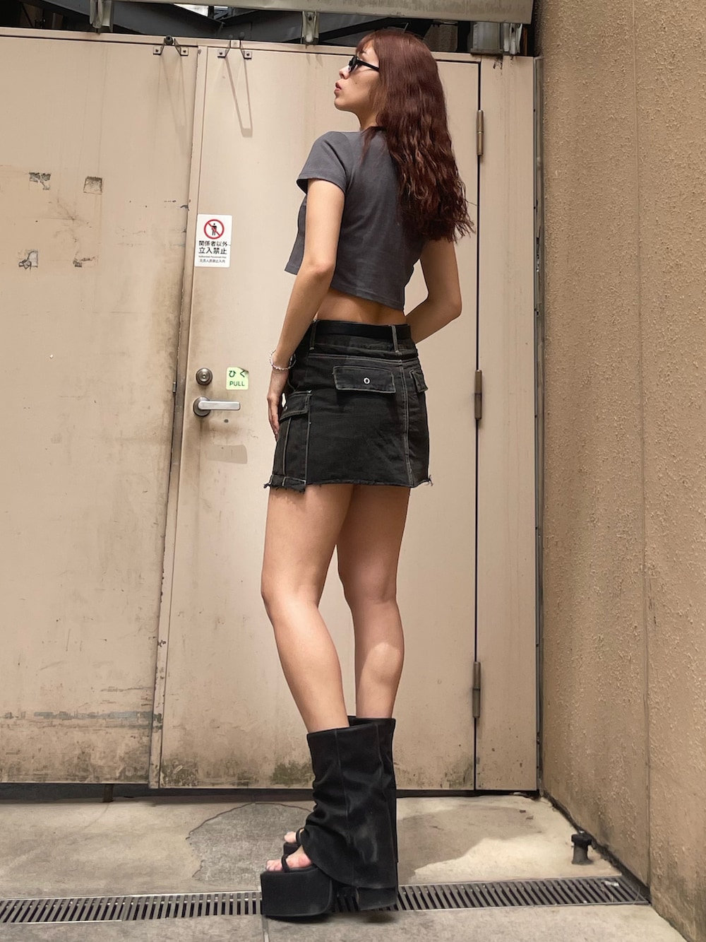 グレー系のTシャツ/カットソー、ブラック系のスカート、ブラック系のサンダルを着用したレディースの春コーディネートの2枚目の写真