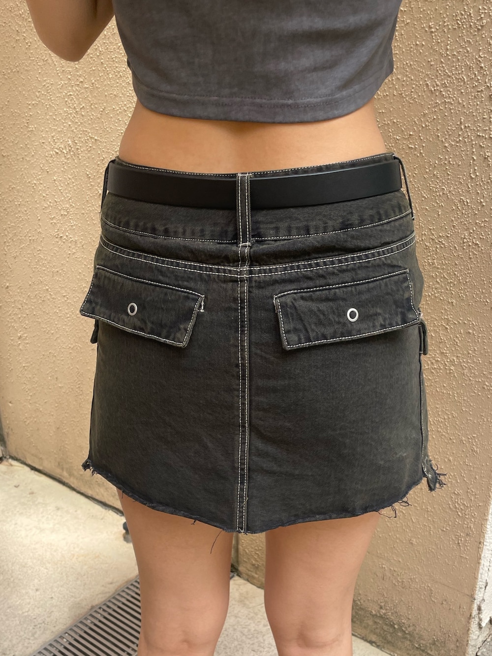 グレー系のTシャツ/カットソー、ブラック系のスカート、ブラック系のサンダルを着用したレディースの春コーディネートの9枚目の写真