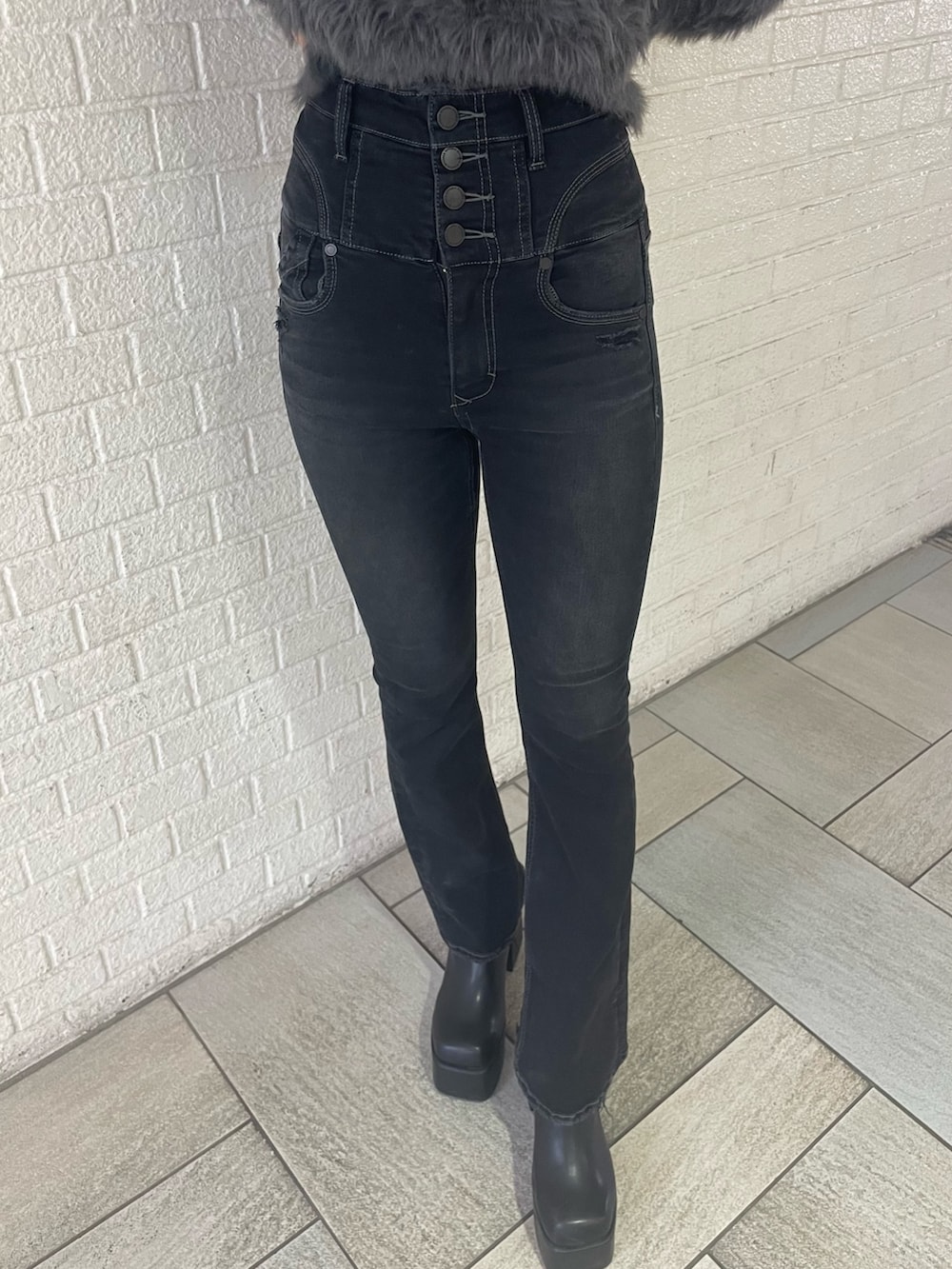 グレー系のニット/セーター、ブラック系のデニムパンツ、ブラック系のブーツを着用したレディースの冬コーディネートの8枚目の写真