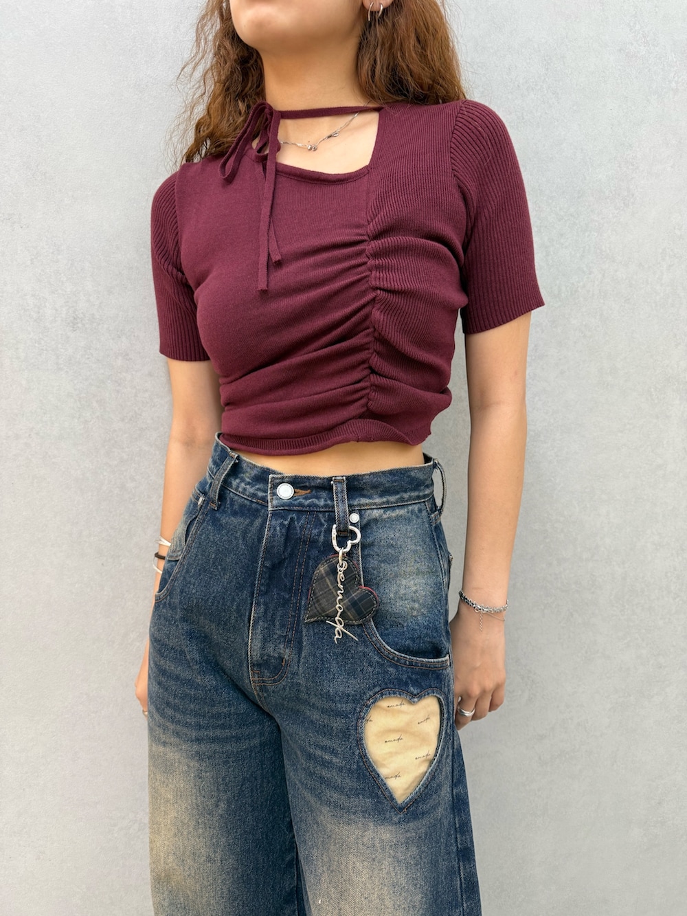 レッド系のニット/セーター、ブルー系のデニムパンツ、ブラック系のブーツを着用したレディースの夏コーディネートの4枚目の写真