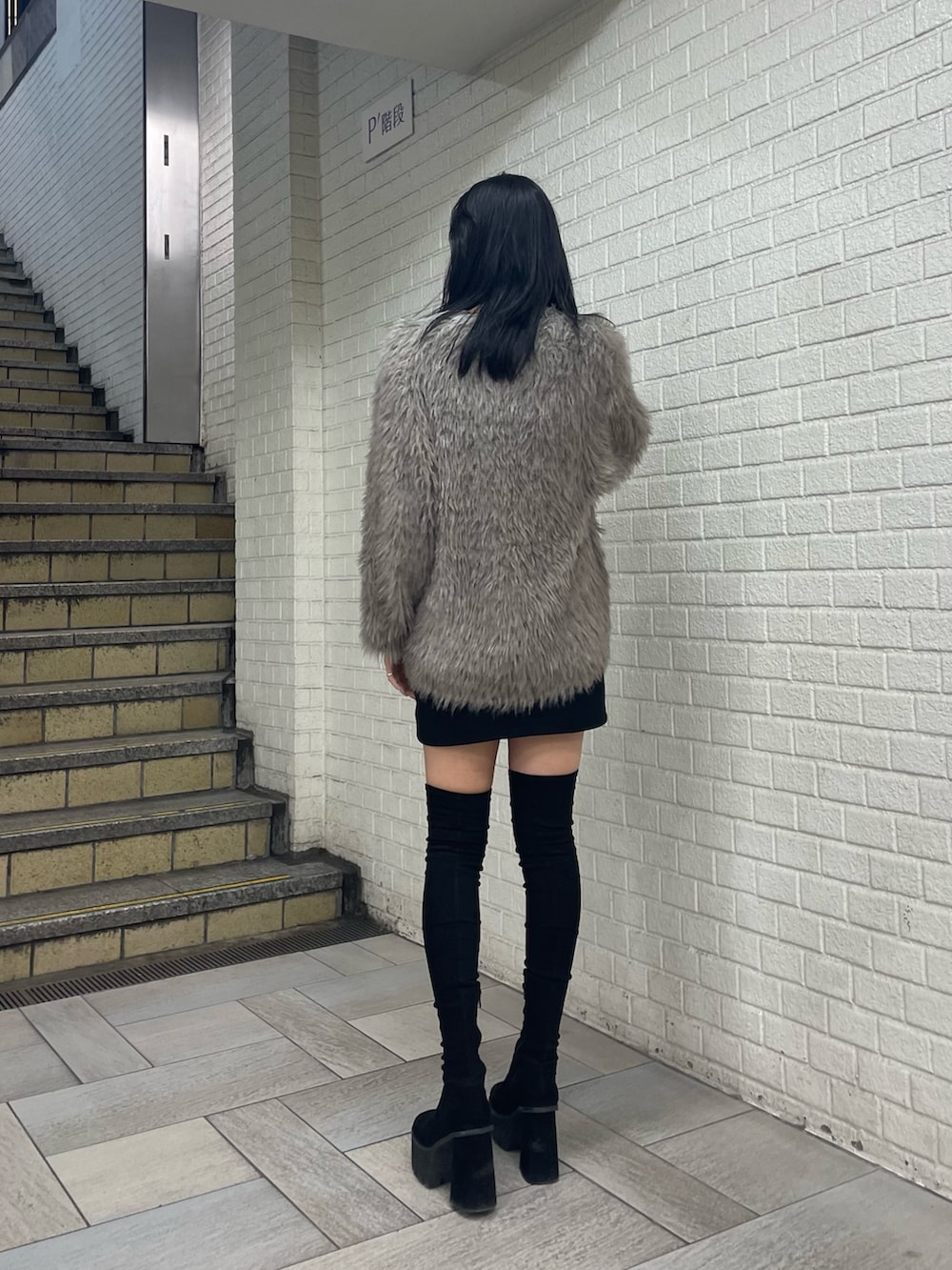 グレー系のカーディガン/ボレロ、ホワイト系のTシャツ/カットソー、ブラック系のスカートを着用したレディースの秋コーディネートの3枚目の写真