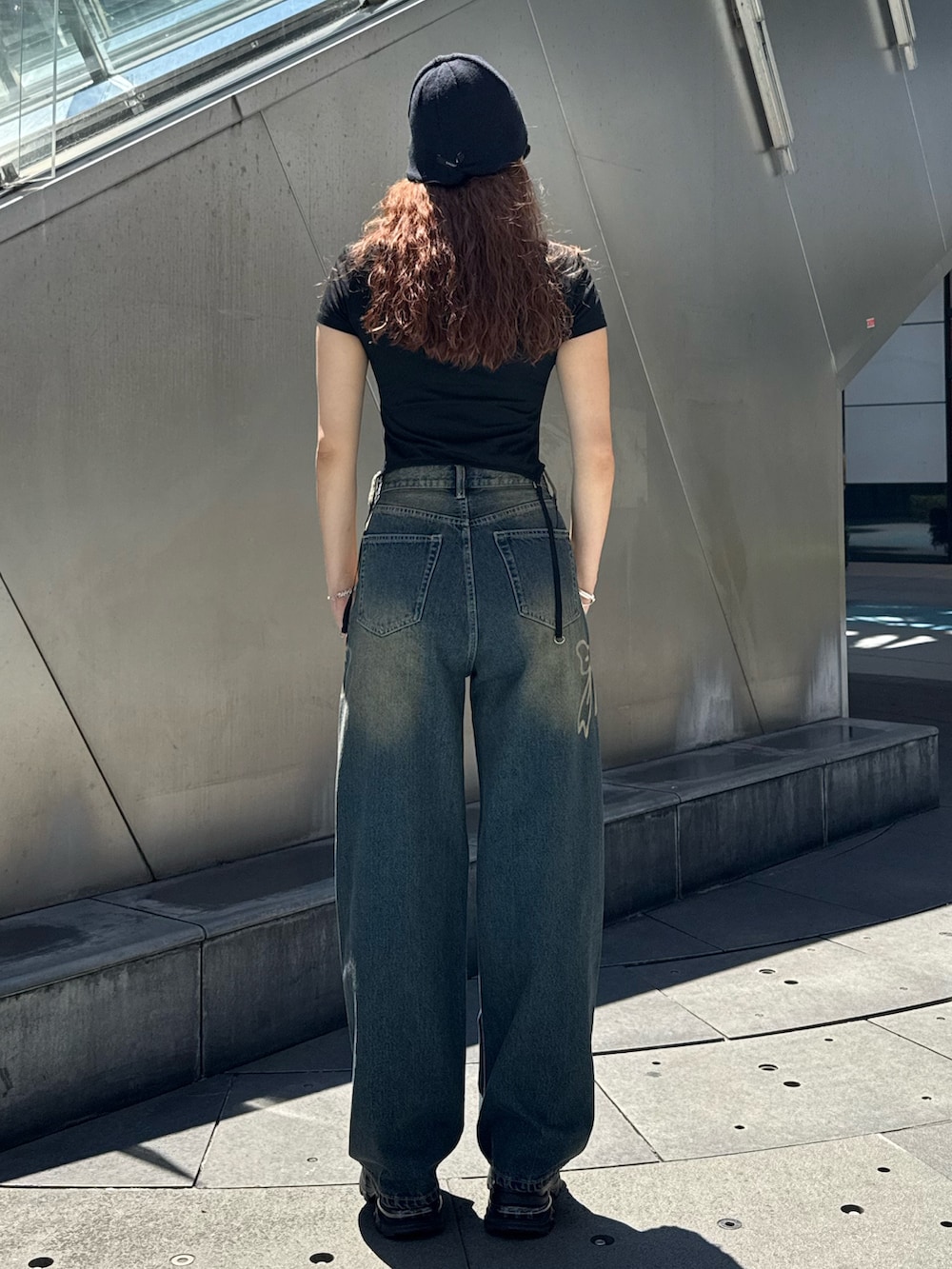 ブラック系のTシャツ/カットソー、ブルー系のデニムパンツ、ブラック系のサンダルを着用したレディースの夏コーディネートの3枚目の写真