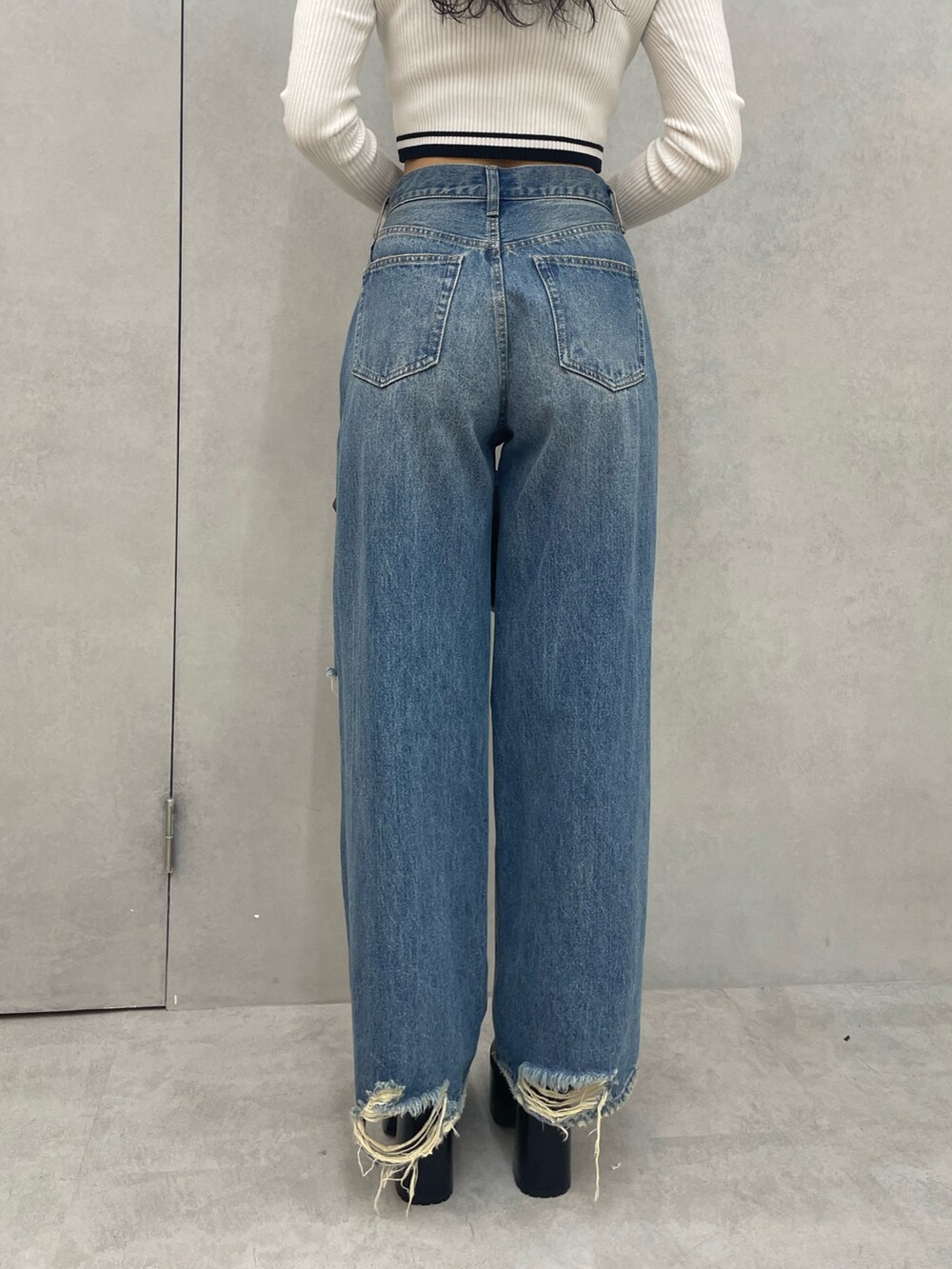 ホワイト系のニット/セーター、ブルー系のデニムパンツ、ブラック系のショルダーバッグを着用したレディースの夏コーディネートの8枚目の写真