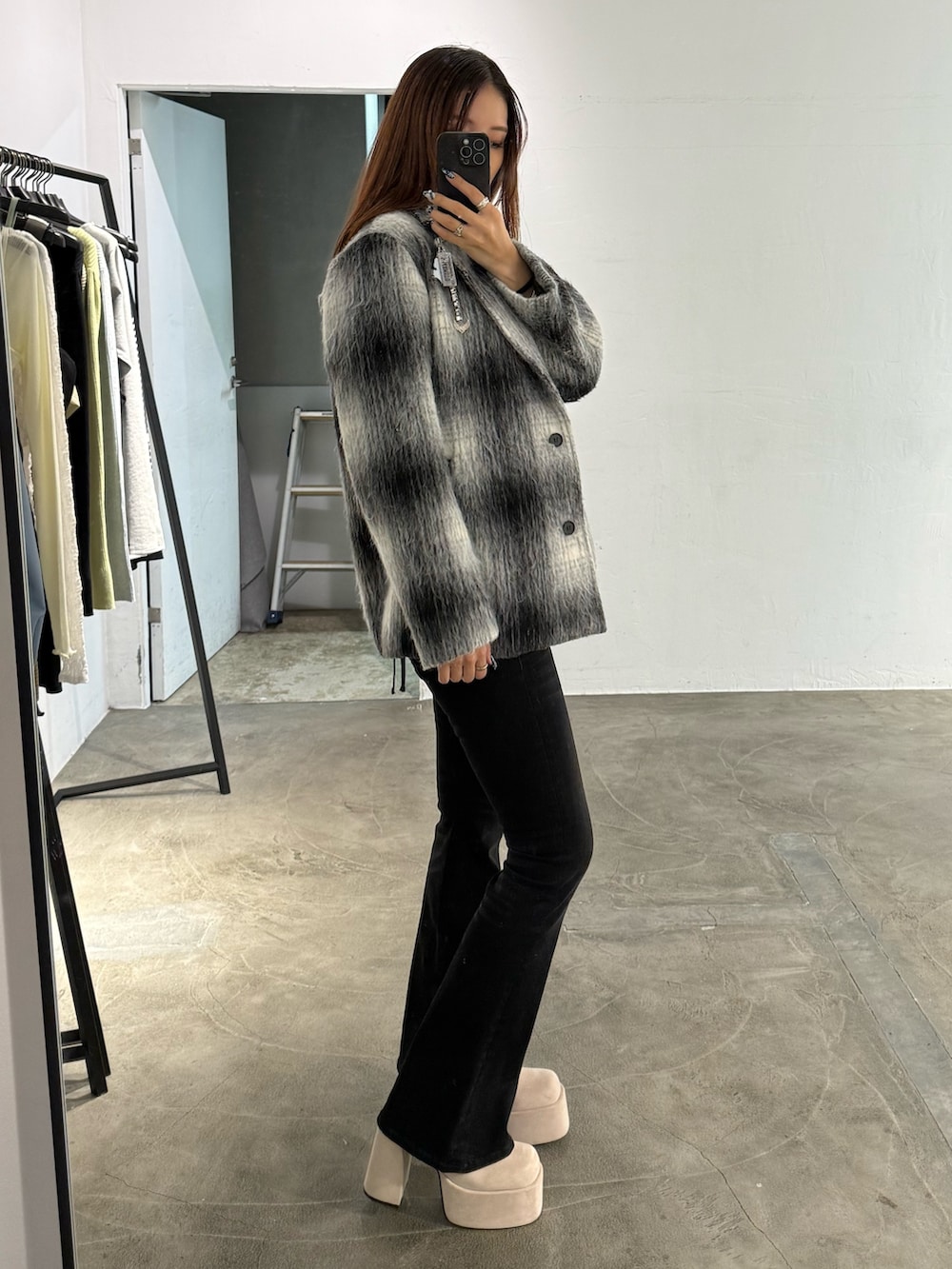 ホワイト系のニット/セーター、ブラック系のその他アウター、ブラック系のデニムパンツを着用したレディースの冬コーディネートの2枚目の写真