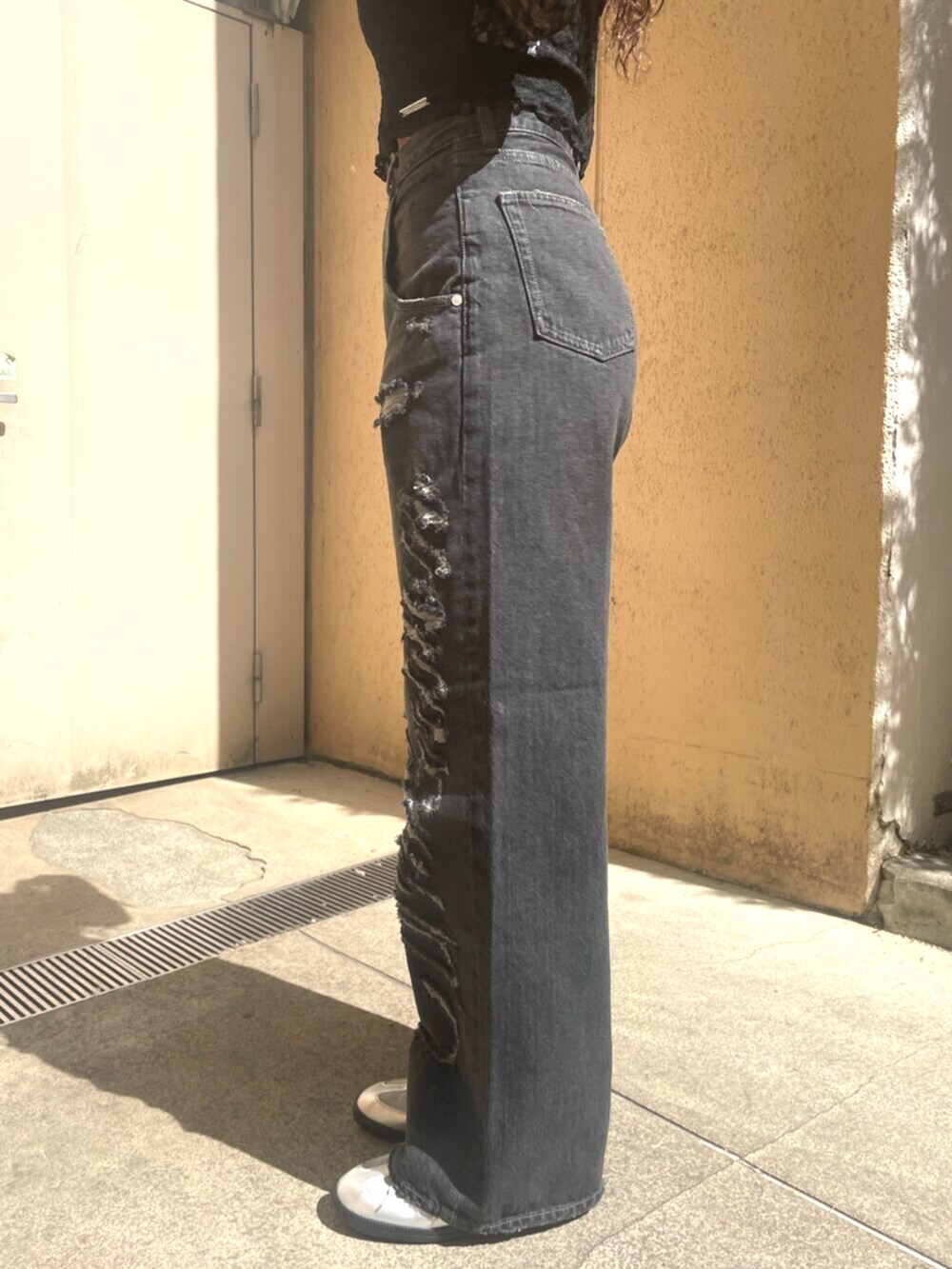 ブラック系のデニムパンツ、ブラック系のハンドバッグ、ブラック系のパンプスを着用したレディースの春コーディネートの8枚目の写真