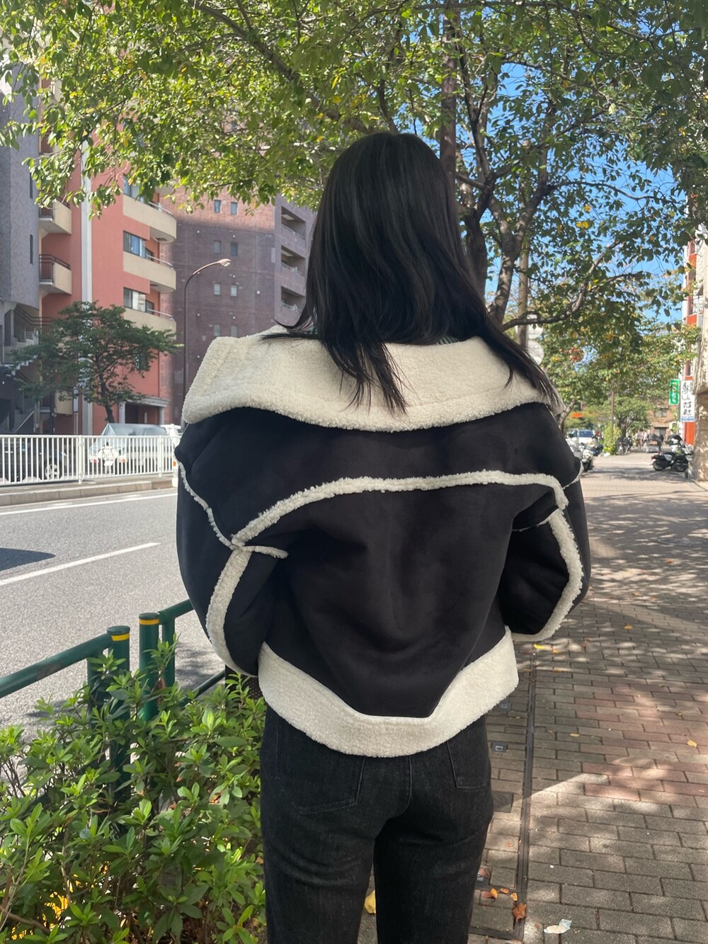 グリーン系のニット/セーター、その他のムートンコート、ブラック系のデニムパンツを着用したレディースの秋コーディネートの5枚目の写真