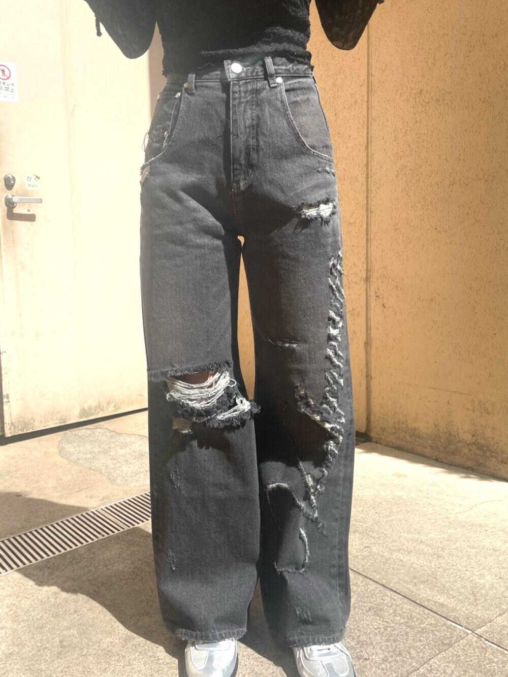 ブラック系のデニムパンツ、ブラック系のハンドバッグ、ブラック系のパンプスを着用したレディースの春コーディネートの7枚目の写真