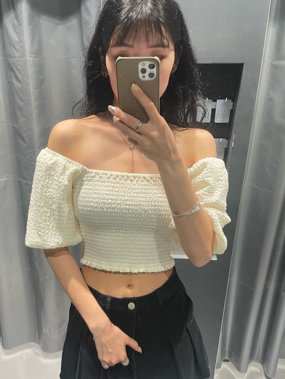 ホワイト系のTシャツ/カットソー、ブラック系のデニムスカート、ブラック系のショルダーバッグを着用したレディースの春コーディネートの5枚目の写真