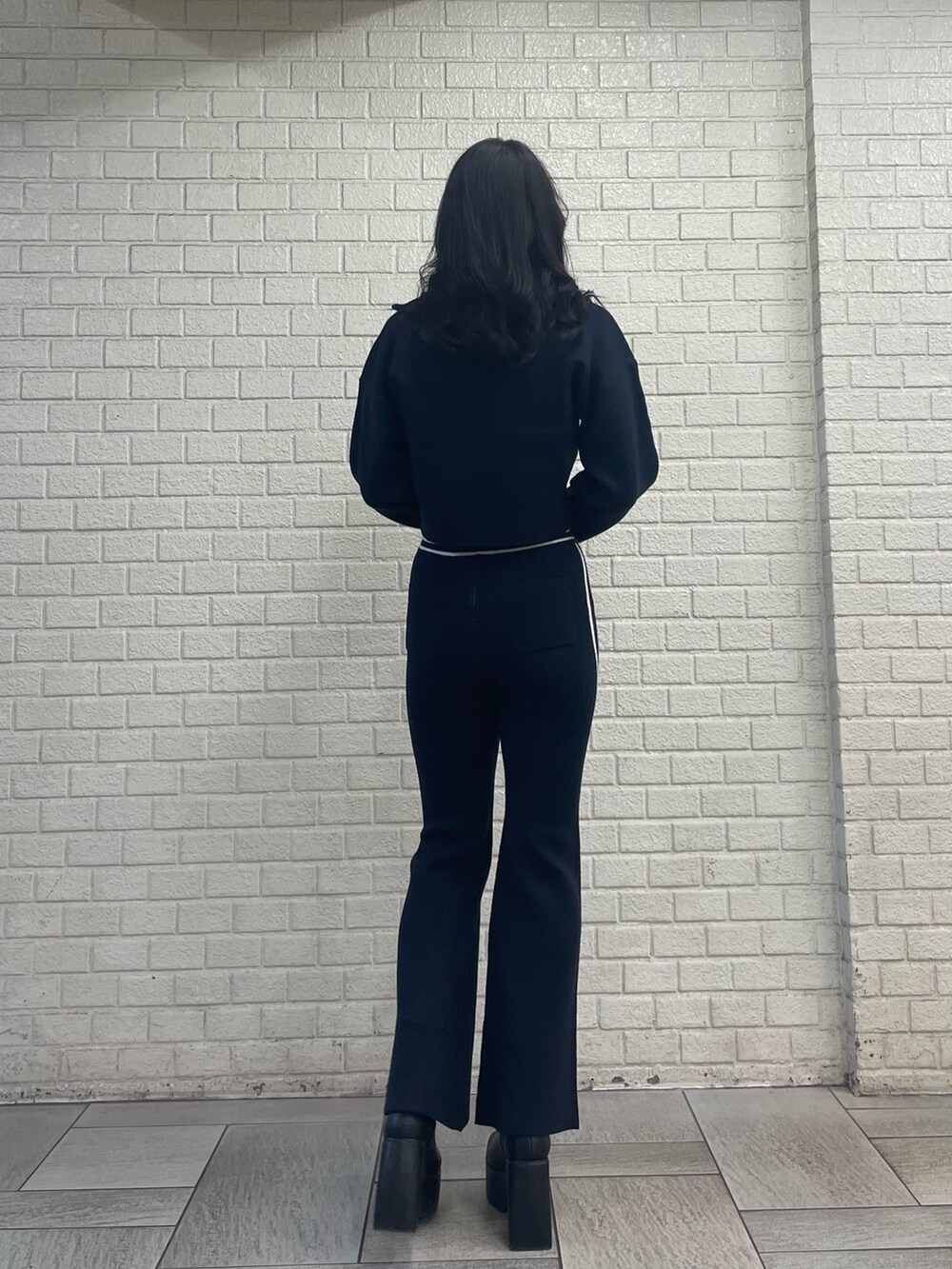 ブルー系のニット/セーター、ブルー系のその他パンツ、ブラック系のブーツを着用したレディースの秋コーディネートの3枚目の写真