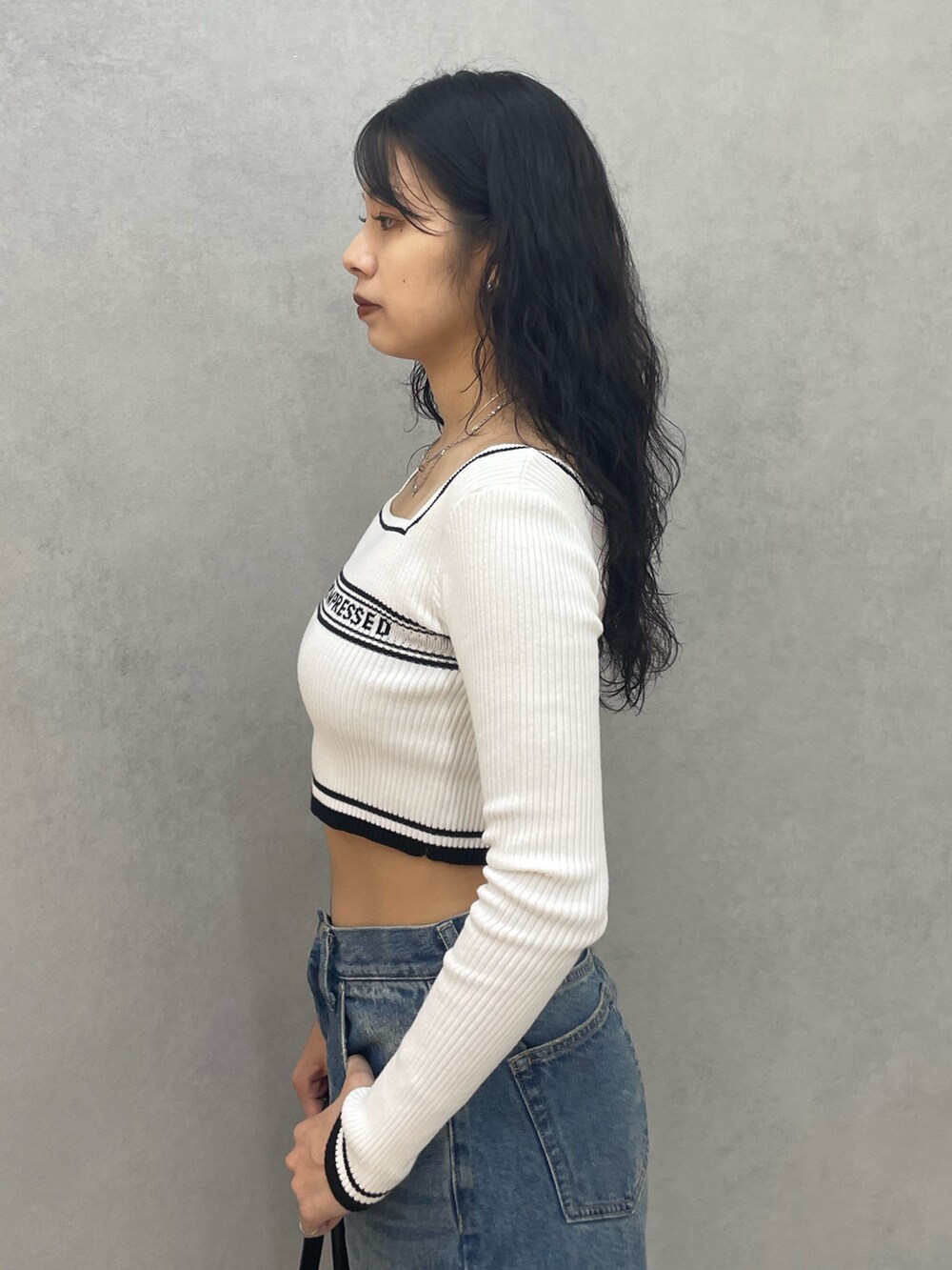 ホワイト系のニット/セーター、ブルー系のデニムパンツ、ブラック系のローファーを着用したレディースの夏コーディネートの5枚目の写真