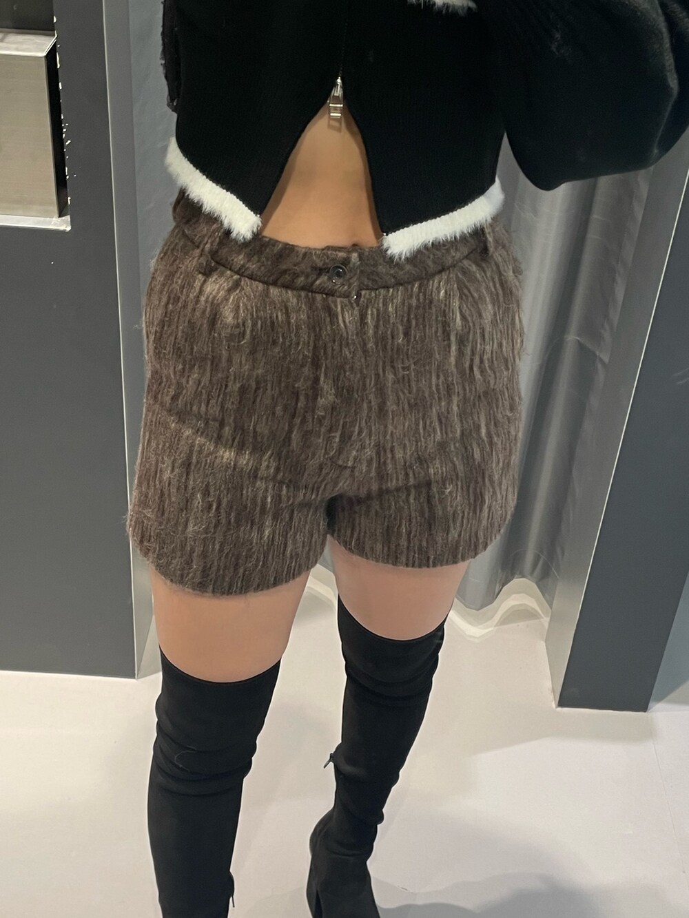 ブラック系のニット/セーター、ブラウン系のその他パンツ、ブラック系のショルダーバッグを着用したレディースの冬コーディネートの6枚目の写真