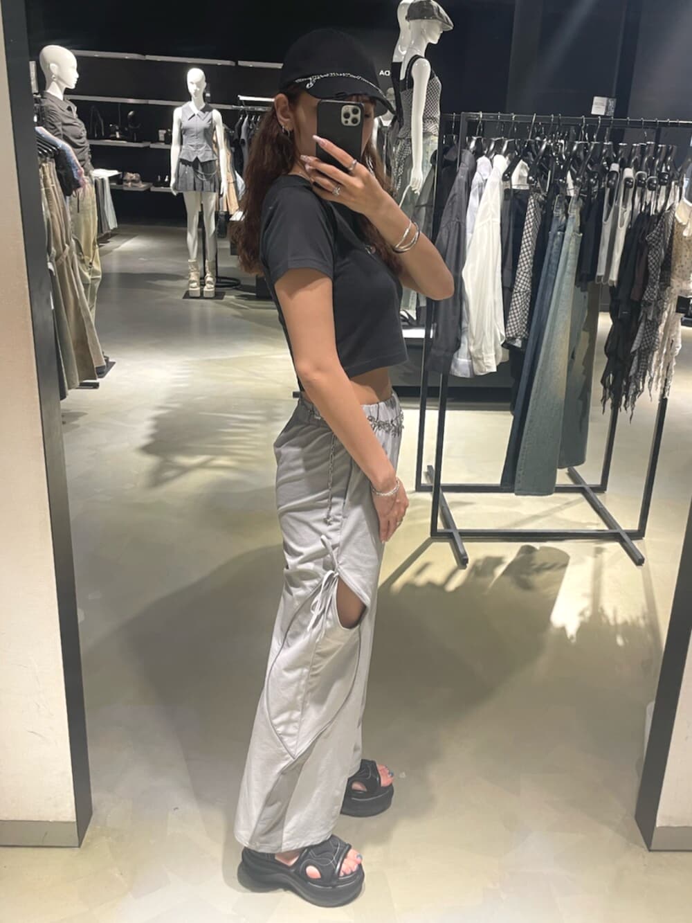 ブラック系のTシャツ/カットソー、グレー系のその他パンツ、ブラック系のサンダルを着用したレディースの春コーディネートの2枚目の写真