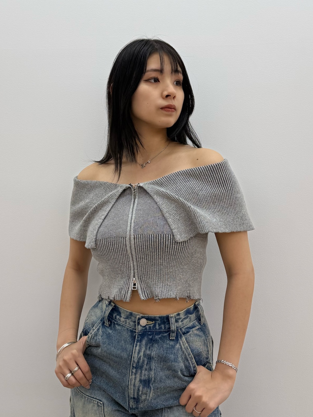 グレー系のニット/セーター、ブルー系のデニムパンツ、ブラック系のサンダルを着用したレディースの春コーディネートの4枚目の写真