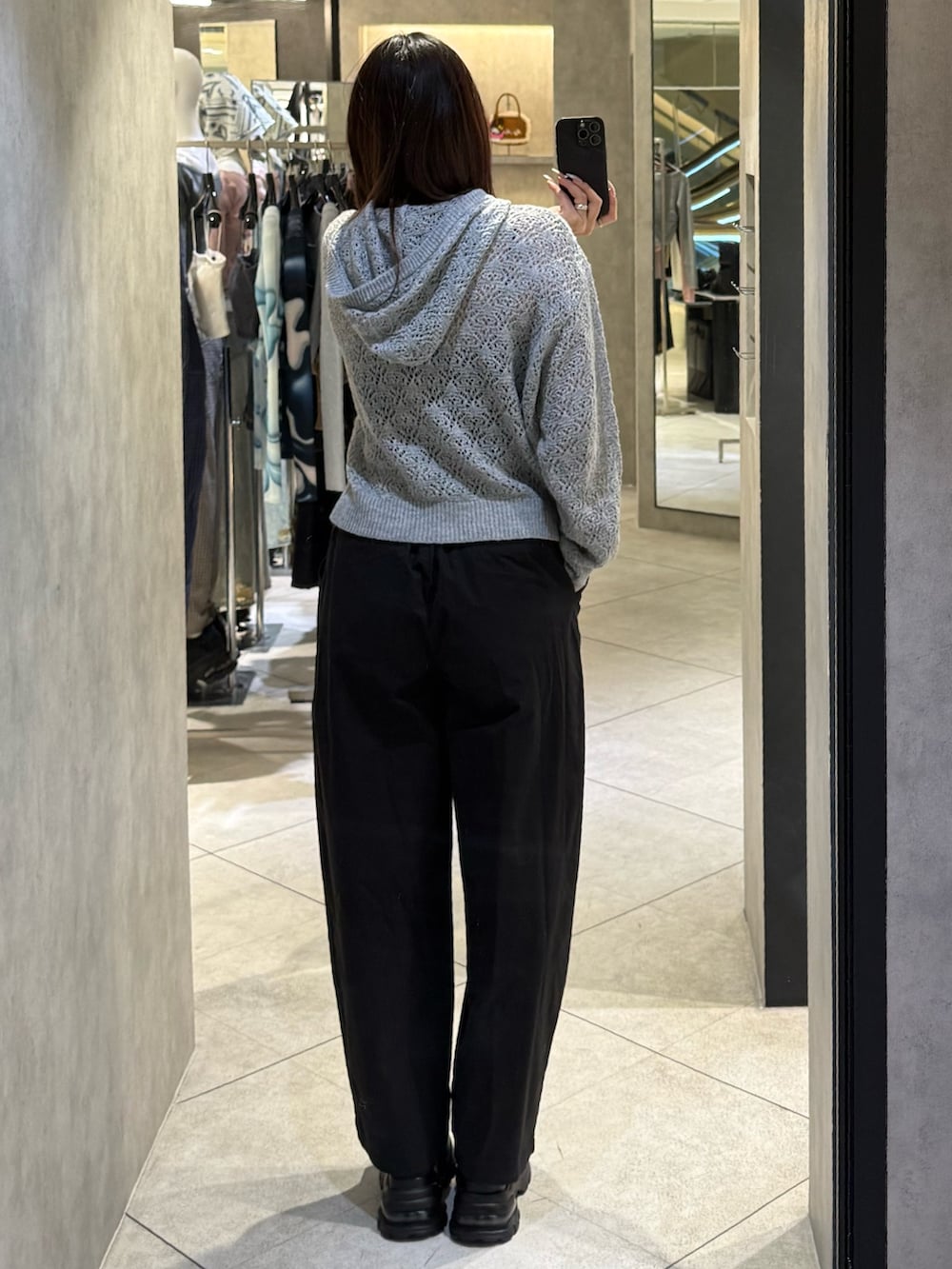 グレー系のパーカー、ブラック系のその他パンツ、ブラック系のスニーカーを着用したレディースの春コーディネートの3枚目の写真