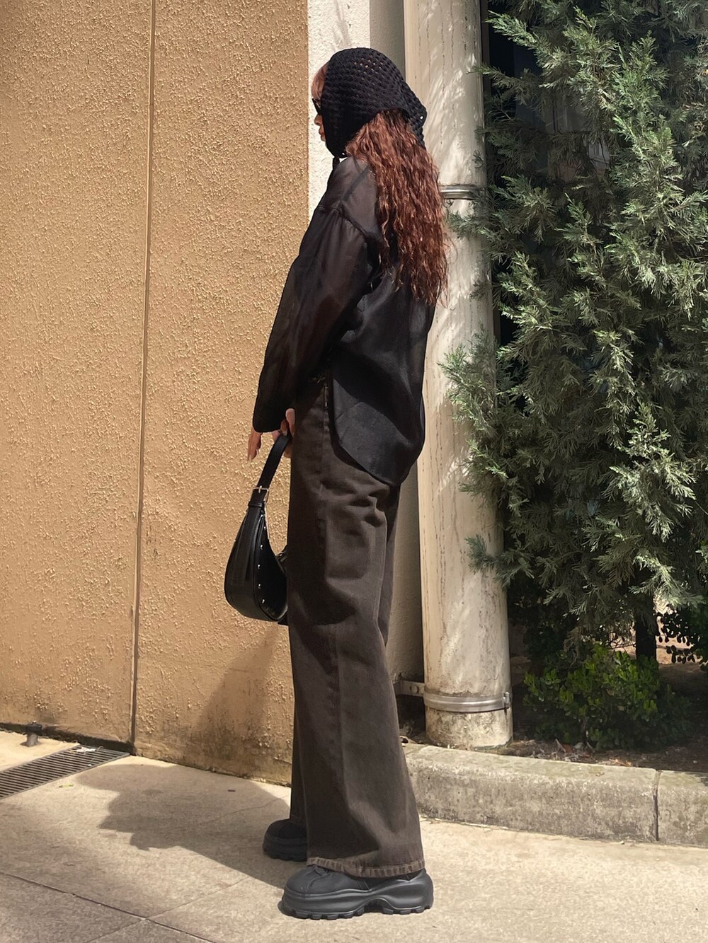 ブラック系のシャツ/ブラウス、ブラック系のニット/セーター、ブラック系のデニムパンツを着用したレディースの春コーディネートの2枚目の写真