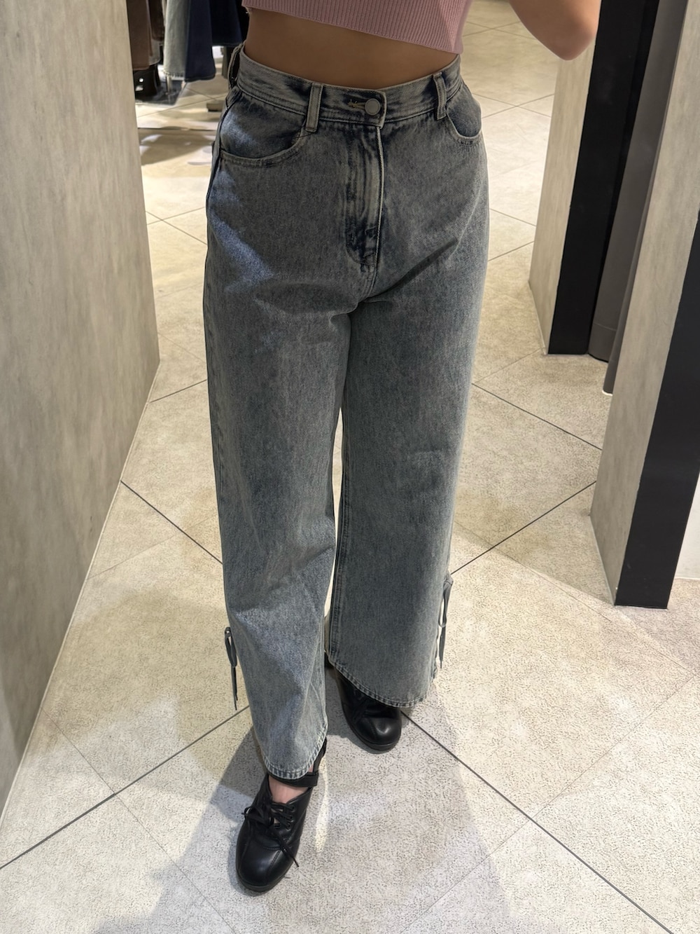 ピンク系のニット/セーター、ブラック系のトートバッグ、ブルー系のデニムパンツを着用したレディースの春コーディネートの6枚目の写真