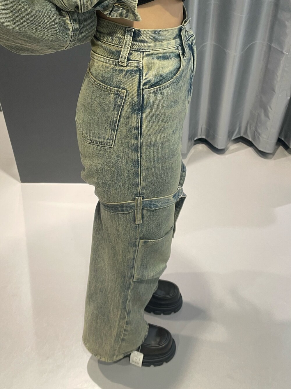 ブラック系のニット/セーター、ブルー系のデニムジャケット、ブルー系のデニムパンツを着用したレディースの冬コーディネートの7枚目の写真