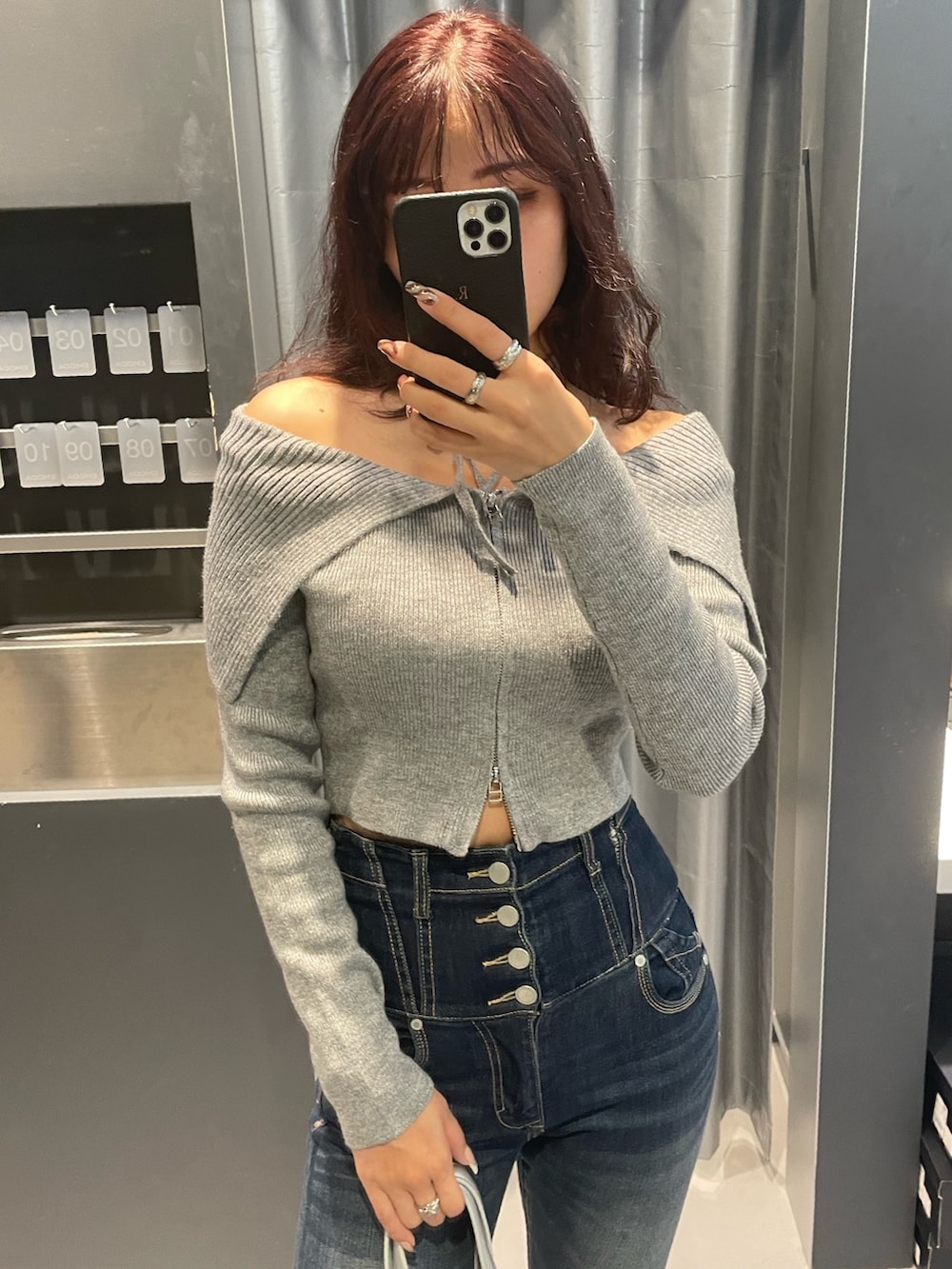 グレー系のニット/セーター、ブルー系のデニムパンツ、シルバー系のショルダーバッグを着用したレディースの冬コーディネートの4枚目の写真