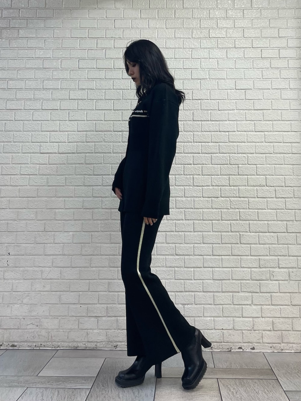 ブラック系のカーディガン/ボレロ、ブラック系のその他パンツ、ブラック系のブーツを着用したレディースの秋コーディネートの2枚目の写真