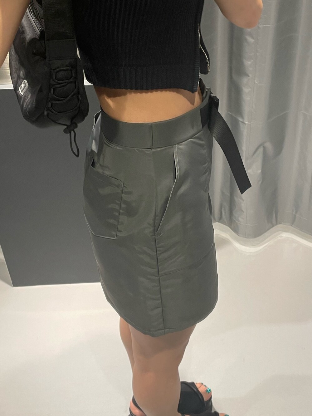 ブラック系のニット/セーター、グレー系のスカート、ブラック系のショルダーバッグを着用したレディースの夏コーディネートの7枚目の写真