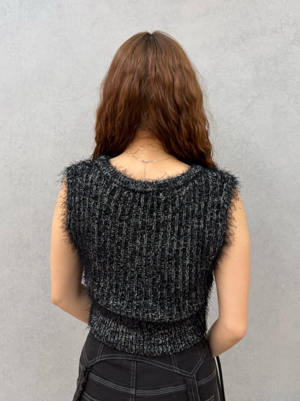 ブラック系のニット/セーター、ブラック系のデニムパンツ、ブラック系のハンドバッグを着用したレディースの夏コーディネートの6枚目の写真