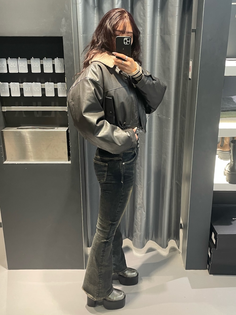 ホワイト系のニット/セーター、グレー系のブルゾン、ブルー系のデニムパンツを着用したレディースの秋コーディネートの2枚目の写真