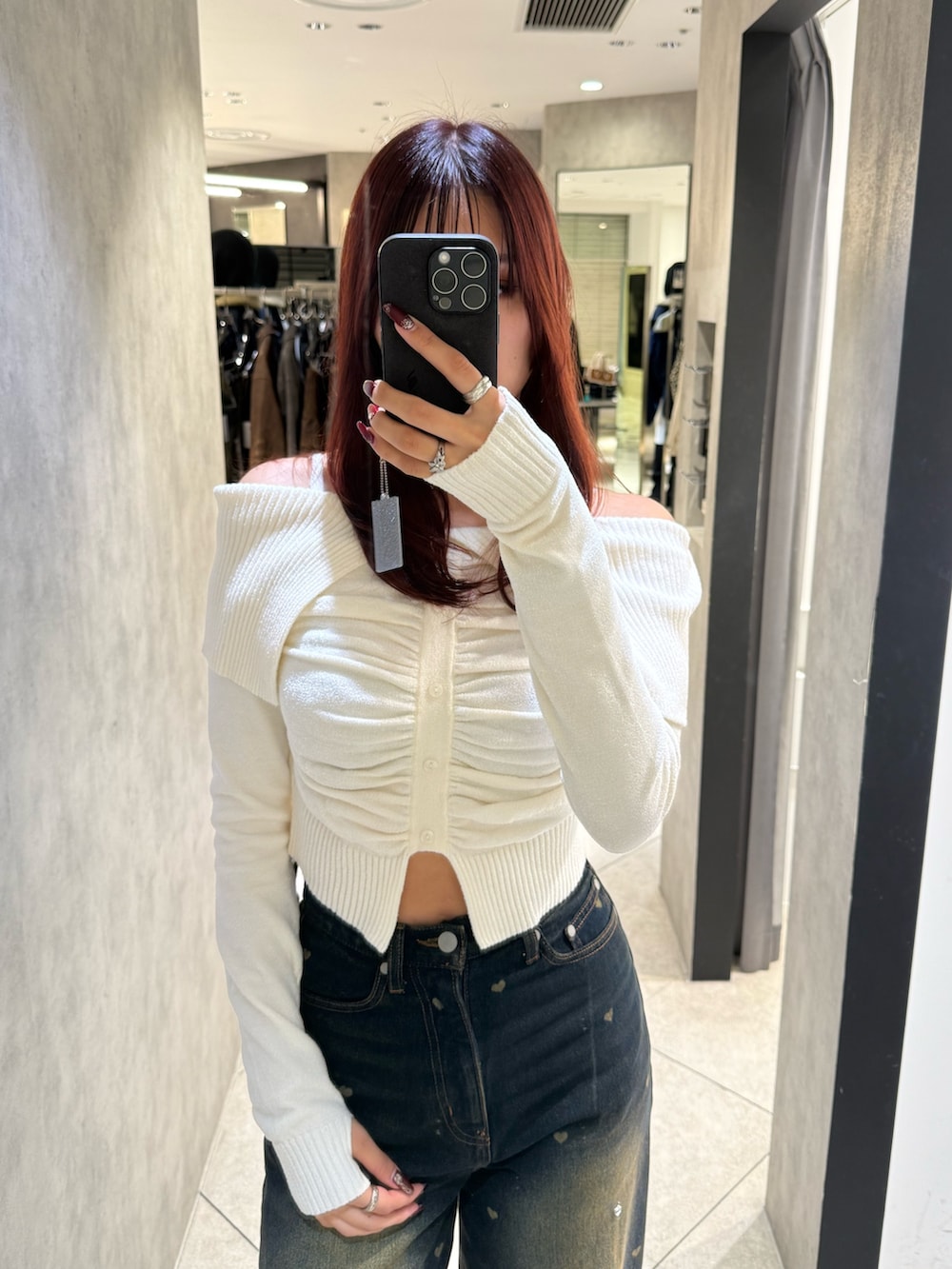 ホワイト系のニット/セーター、ブルー系のデニムパンツ、ブラック系のブーツを着用したレディースの秋コーディネートの4枚目の写真