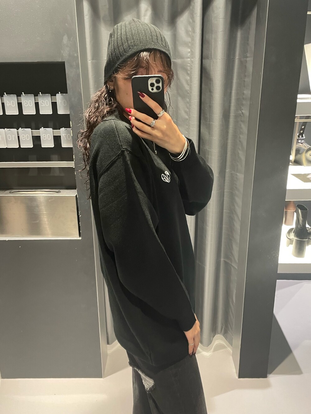 ブラック系のワンピース、ブラック系のデニムパンツ、ブラック系のブーツを着用したレディースの秋コーディネートの5枚目の写真