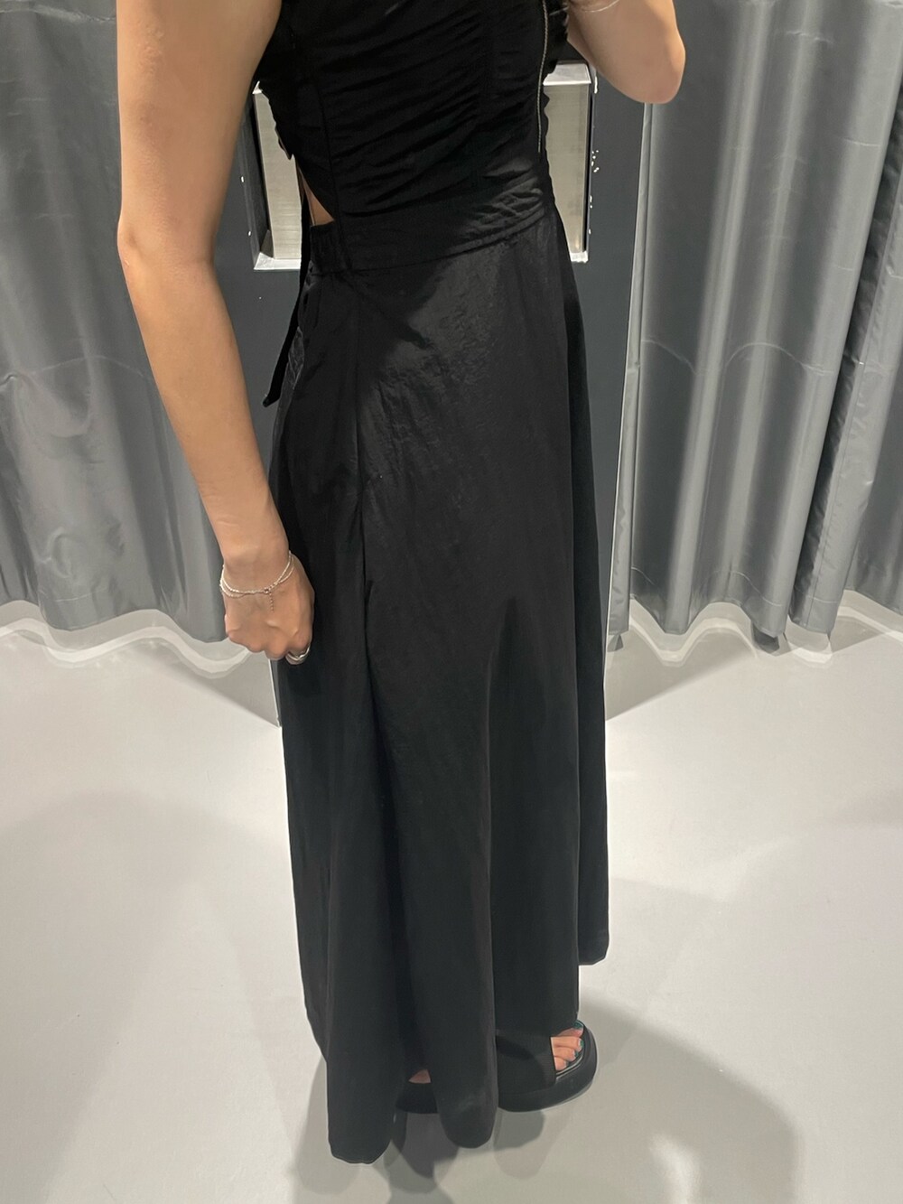 ブラック系のワンピース、ブラック系のサンダル、シルバー系のネックレスを着用したレディースの夏コーディネートの7枚目の写真