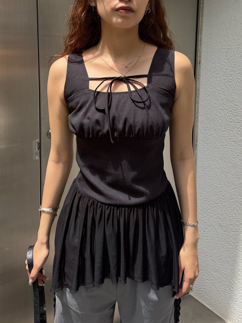 ブラック系のTシャツ/カットソー、ブラック系のハンドバッグ、グレー系のその他パンツを着用したレディースの夏コーディネートの4枚目の写真