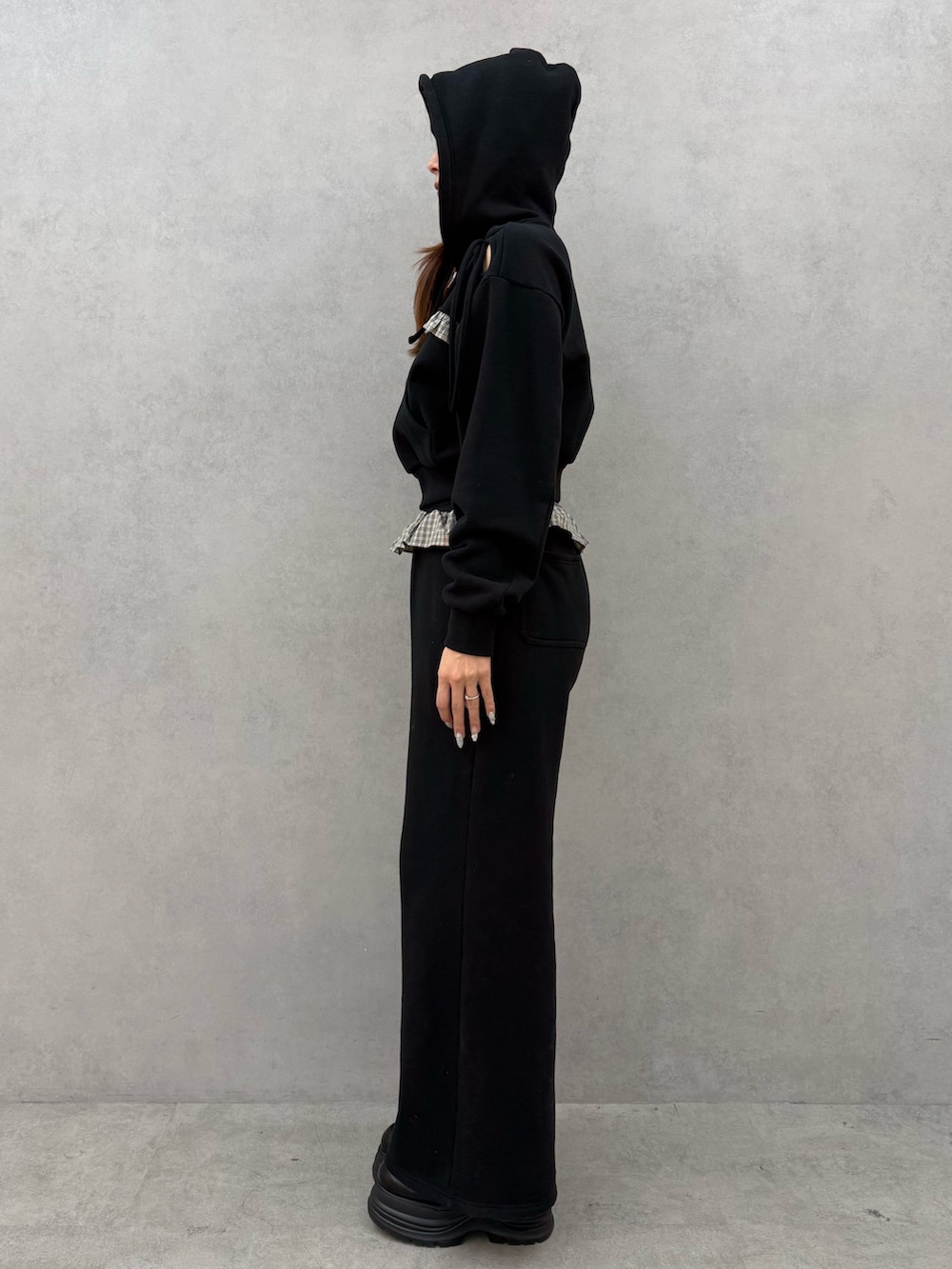 ブラック系のパーカー、ブラック系のスウェットパンツ、ブラック系のローファーを着用したレディースの冬コーディネートの2枚目の写真