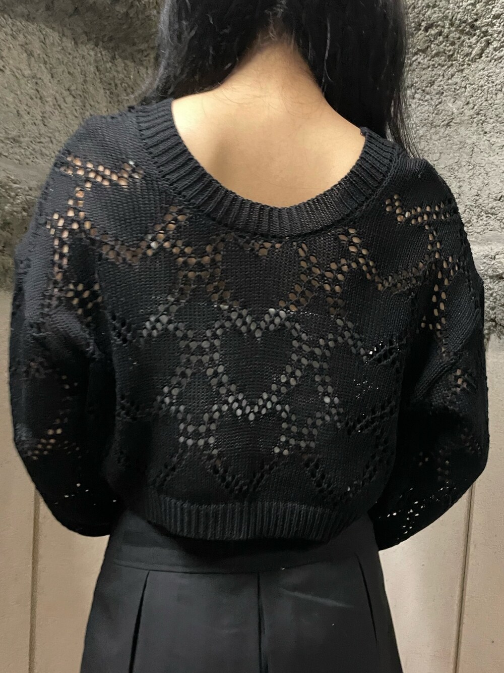 ブラック系のニット/セーター、ホワイト系のキャミソール、ブラック系のスカートを着用したレディースの春コーディネートの6枚目の写真