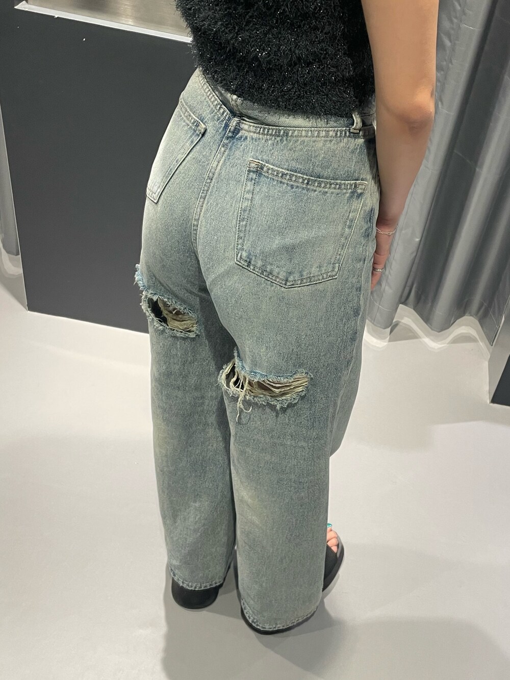 ホワイト系のTシャツ/カットソー、ブルー系のデニムパンツ、ブラック系のハンドバッグを着用したレディースの秋コーディネートの8枚目の写真