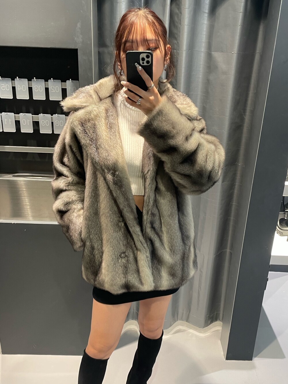 ホワイト系のニット/セーター、グレー系のその他アウター、ブラック系のスカートを着用したレディースの冬コーディネートの6枚目の写真