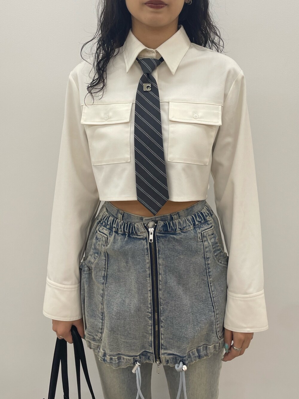 ホワイト系のシャツ/ブラウス、ブルー系のデニムパンツ、ブラック系のショルダーバッグを着用したレディースの夏コーディネートの4枚目の写真