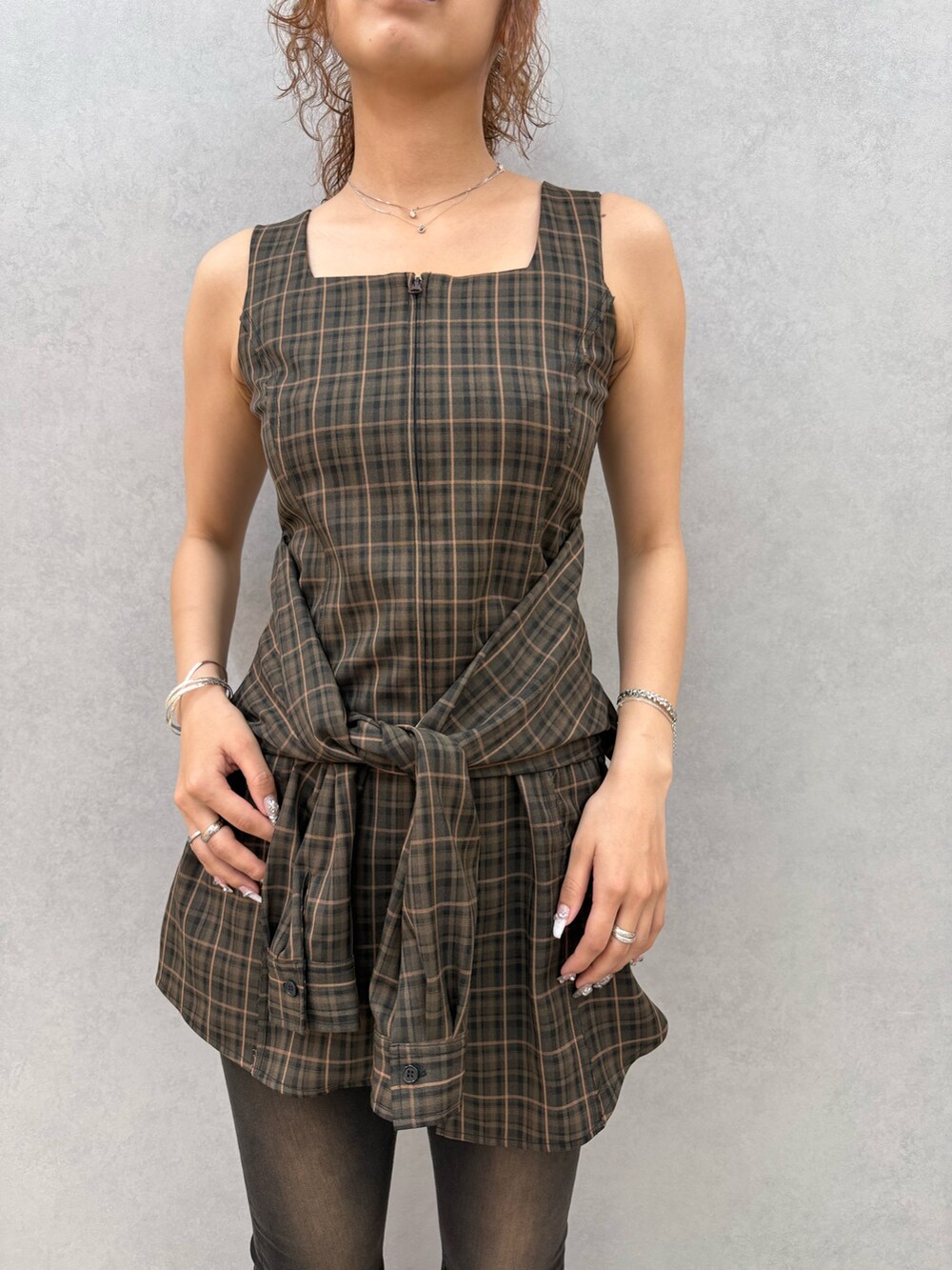 ブラウン系のワンピース、ブラック系のデニムパンツ、ブラック系のサンダルを着用したレディースの夏コーディネートの4枚目の写真