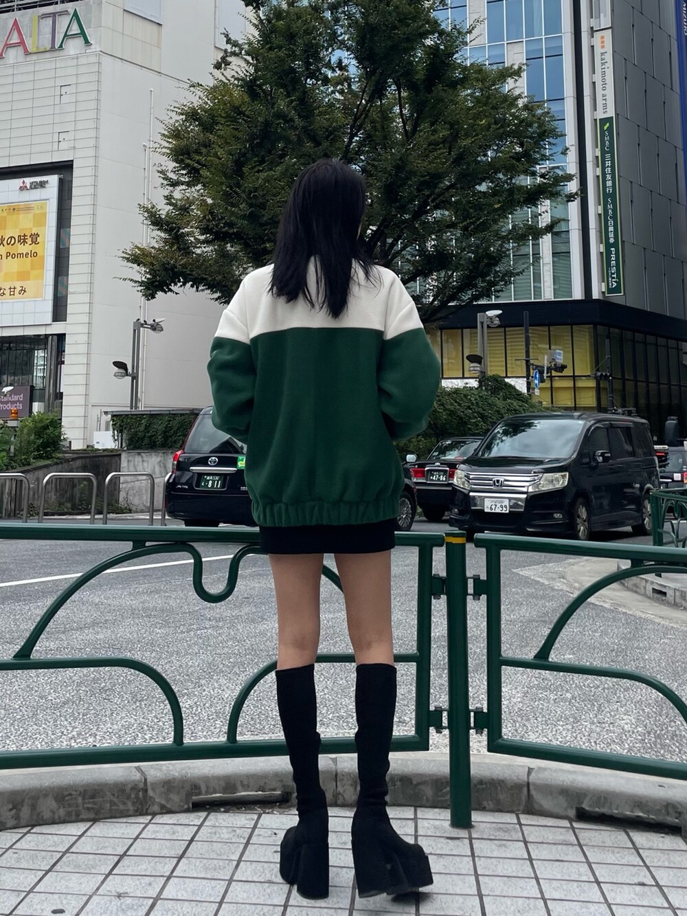 グリーン系のブルゾン、ブラック系のスカート、その他のブーツを着用したレディースの秋コーディネートの3枚目の写真