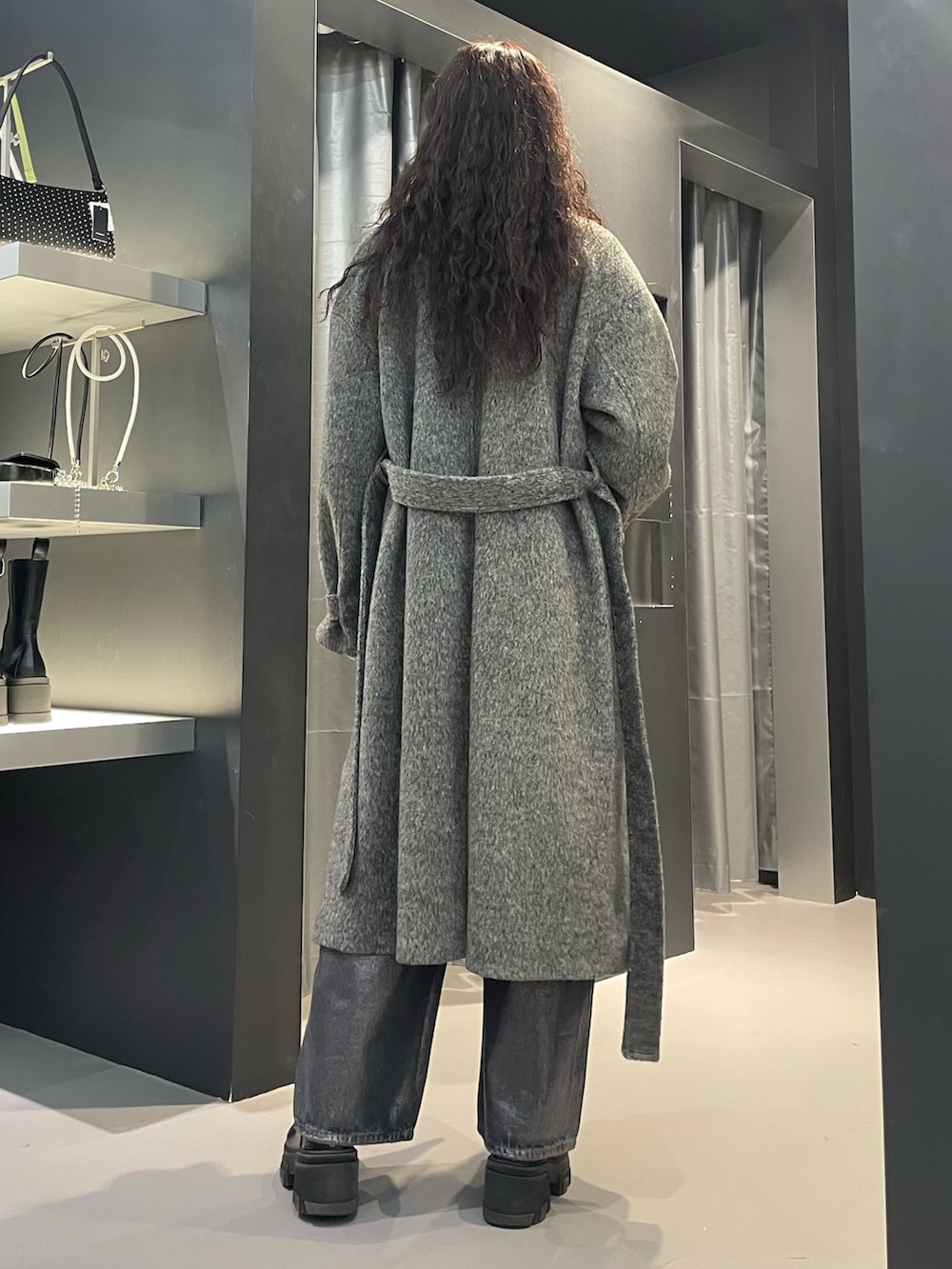 ブラック系のニット/セーター、グレー系のその他アウター、ブルー系のデニムパンツを着用したレディースの冬コーディネートの3枚目の写真