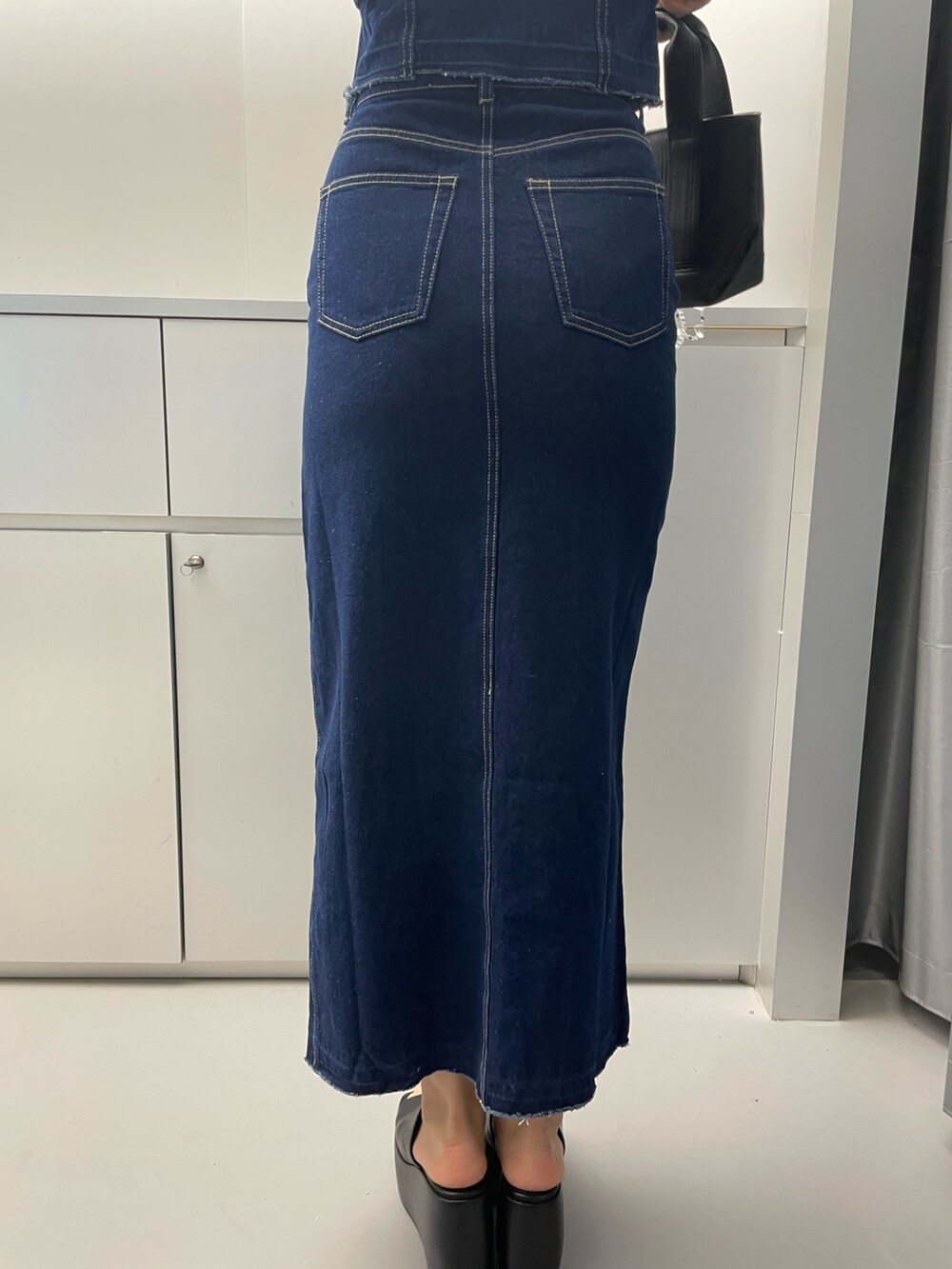 ブルー系のシャツ/ブラウス、ブルー系のスカート、ブラック系のハンドバッグを着用したレディースの春コーディネートの9枚目の写真