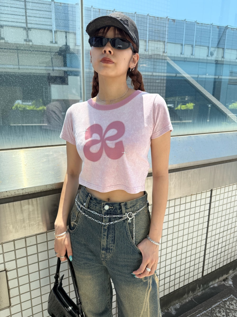 ピンク系のTシャツ/カットソー、ブルー系のデニムパンツ、ブラック系のショルダーバッグを着用したレディースの夏コーディネートの4枚目の写真