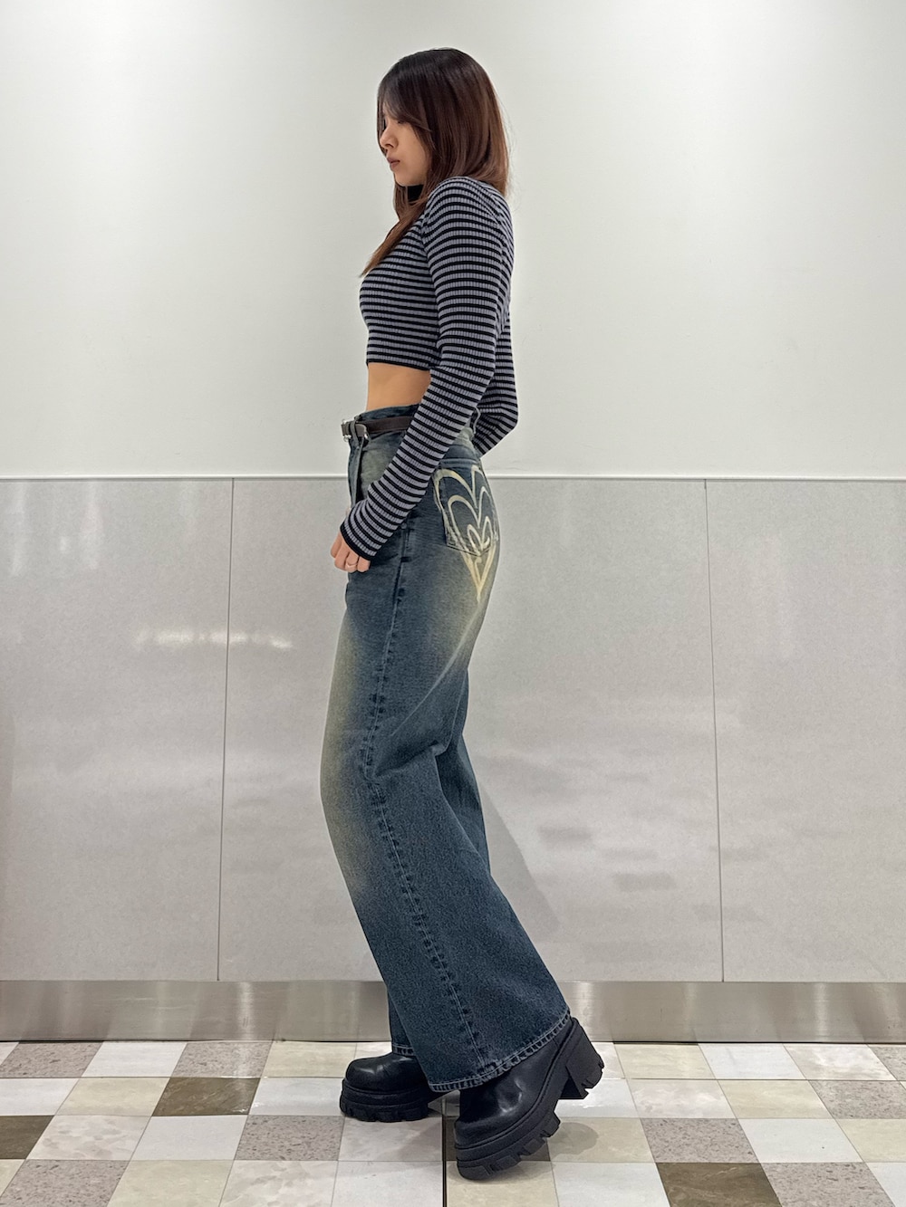 ブルー系のニット/セーター、ブルー系のデニムパンツ、ブラック系のブーツを着用したレディースの冬コーディネートの2枚目の写真