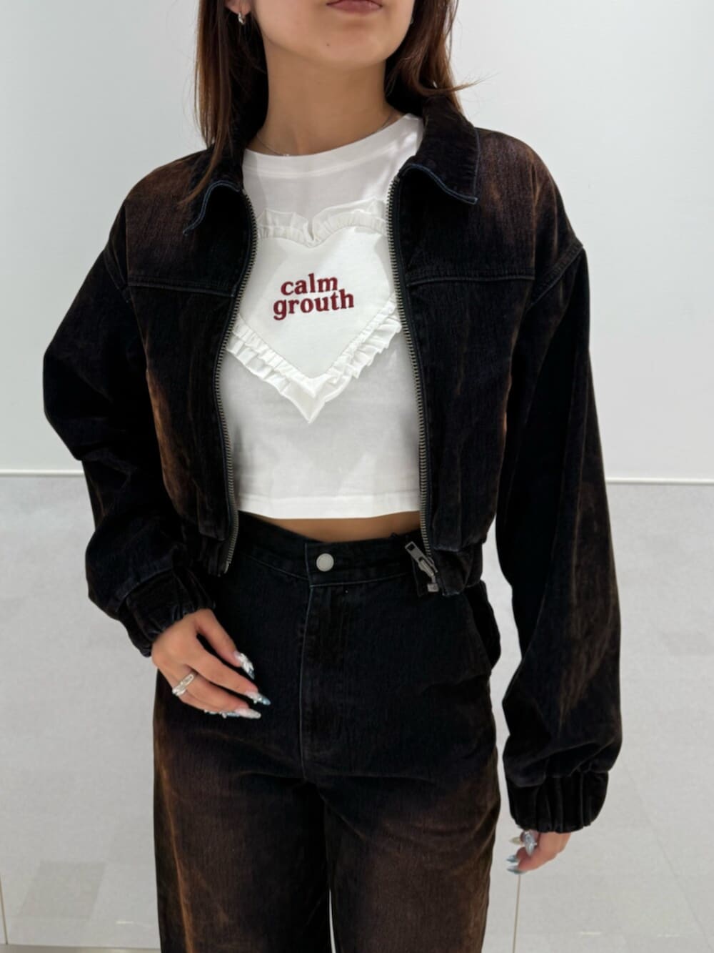 ブラウン系のブルゾン、ホワイト系のTシャツ/カットソー、ブラウン系のデニムパンツを着用したレディースの夏コーディネートの4枚目の写真