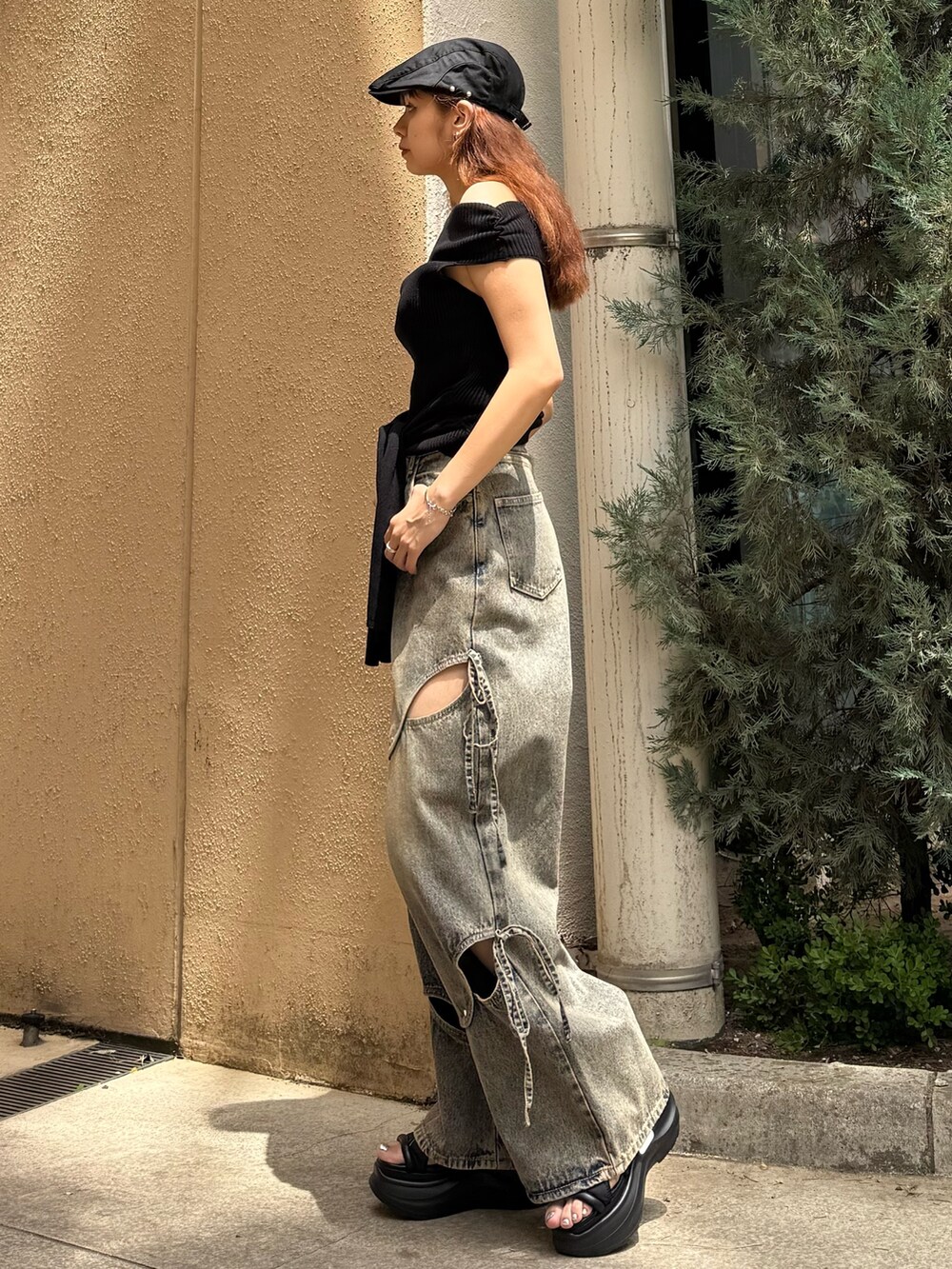 ブラック系のニット/セーター、ブルー系のデニムパンツ、ブラック系のサンダルを着用したレディースの夏コーディネートの2枚目の写真