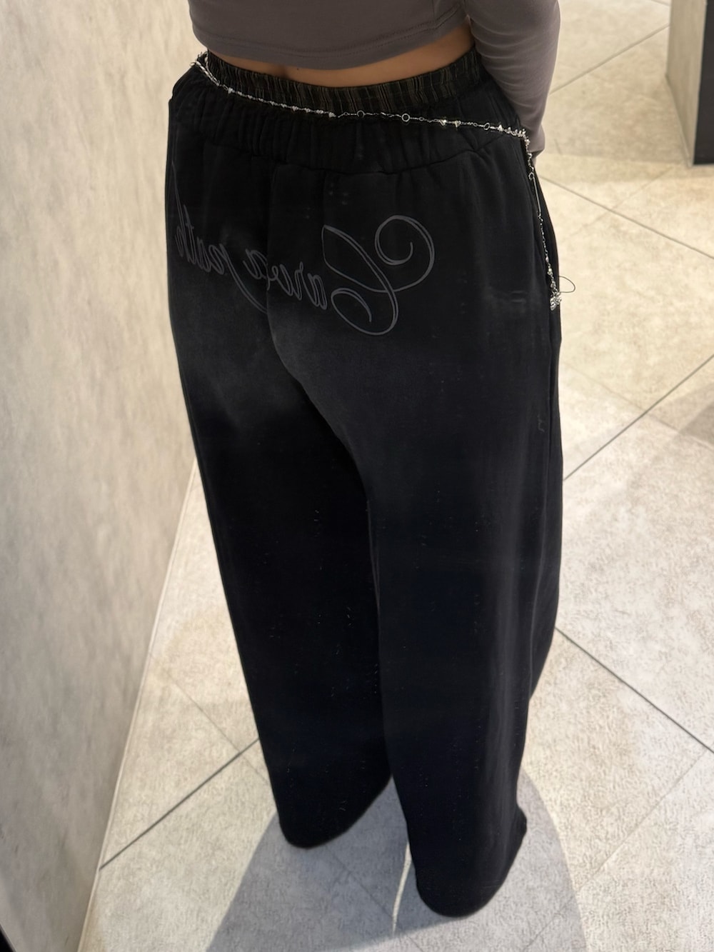 グレー系のTシャツ/カットソー、ブラック系のスウェットパンツ、ブラック系のスニーカーを着用したレディースの春コーディネートの6枚目の写真