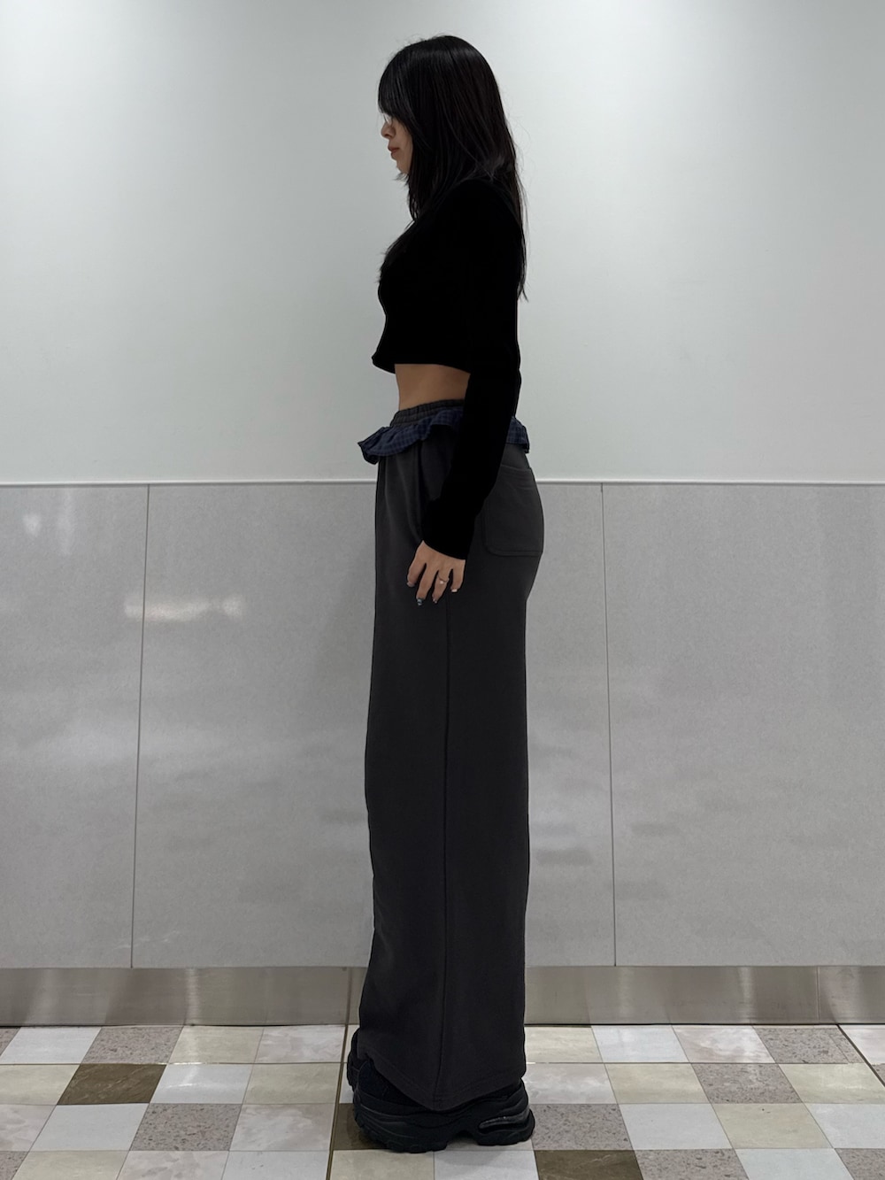 ブラック系のTシャツ/カットソー、グレー系のスウェットパンツ、ブラック系のスニーカーを着用したレディースの冬コーディネートの2枚目の写真