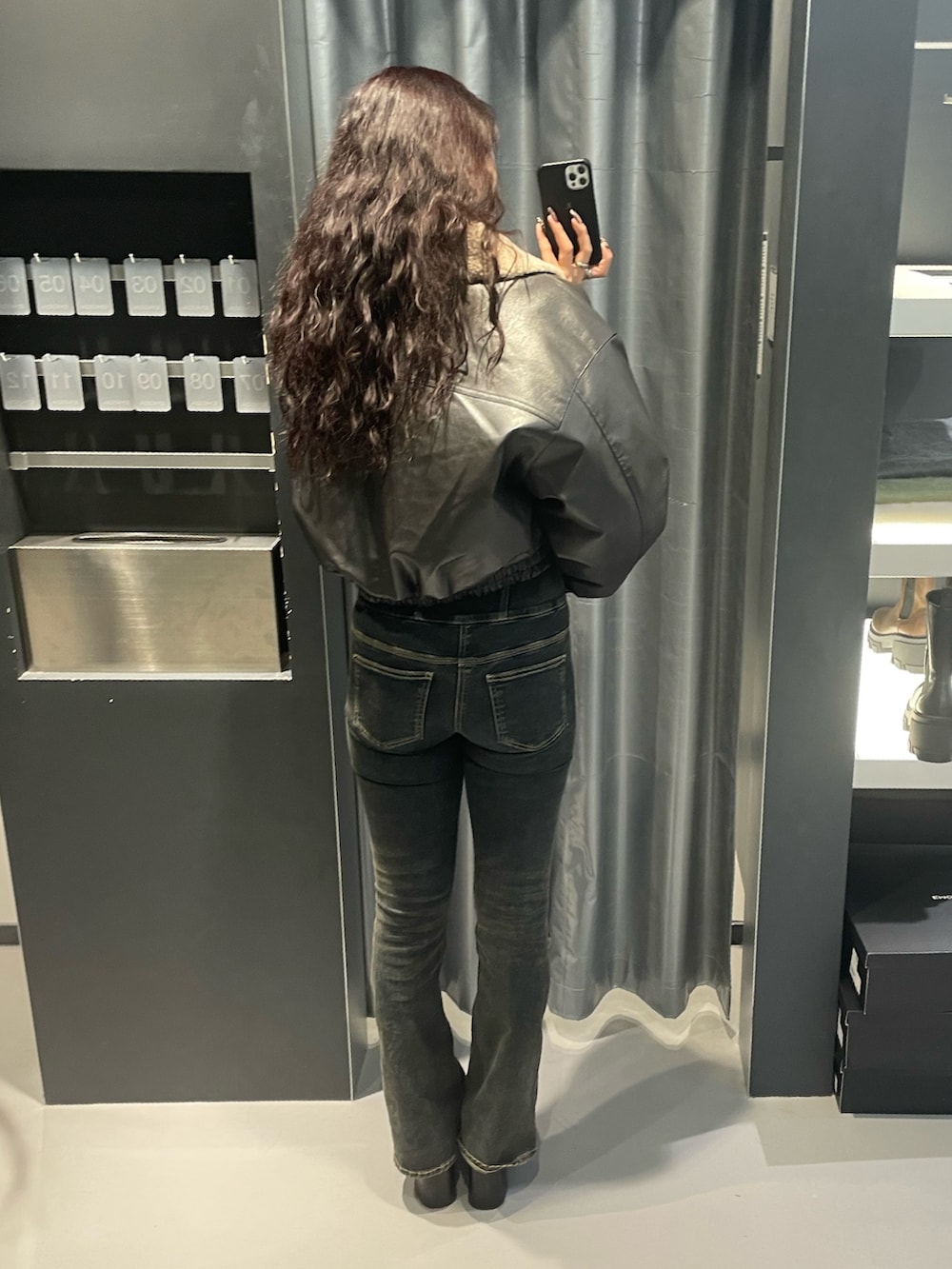 ホワイト系のニット/セーター、グレー系のブルゾン、ブルー系のデニムパンツを着用したレディースの秋コーディネートの3枚目の写真