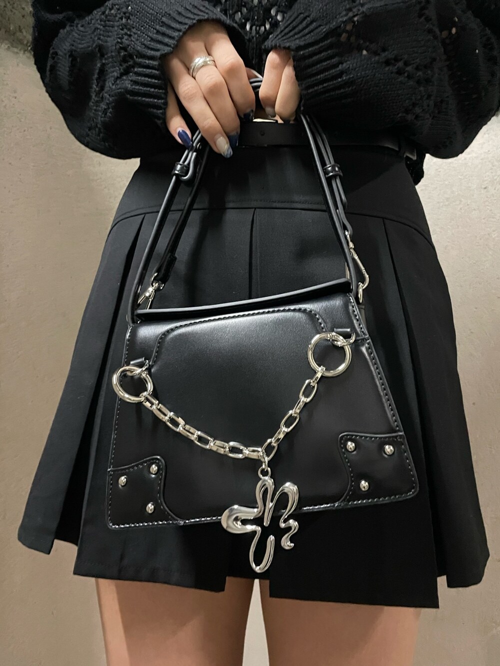 ブラック系のニット/セーター、ホワイト系のキャミソール、ブラック系のスカートを着用したレディースの春コーディネートの9枚目の写真