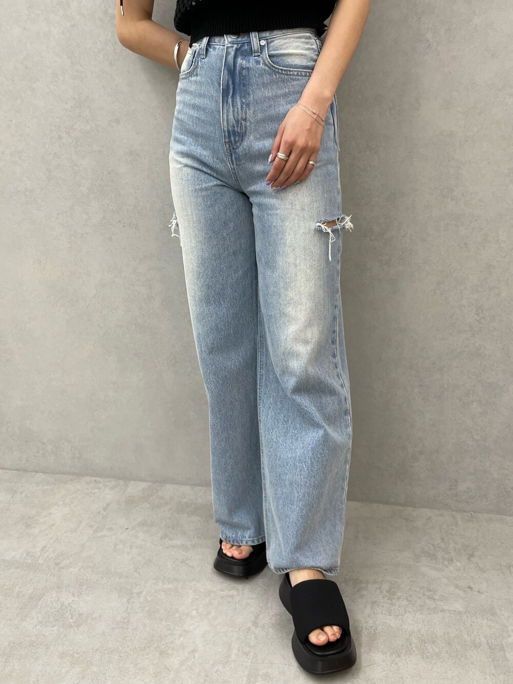 ブラック系のタンクトップ、ホワイト系のキャミソール、ブルー系のデニムパンツを着用したレディースの春コーディネートの7枚目の写真