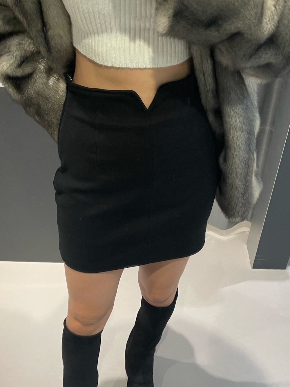 ホワイト系のニット/セーター、ブラック系のスカート、ブラック系のブルゾンを着用したレディースの冬コーディネートの6枚目の写真